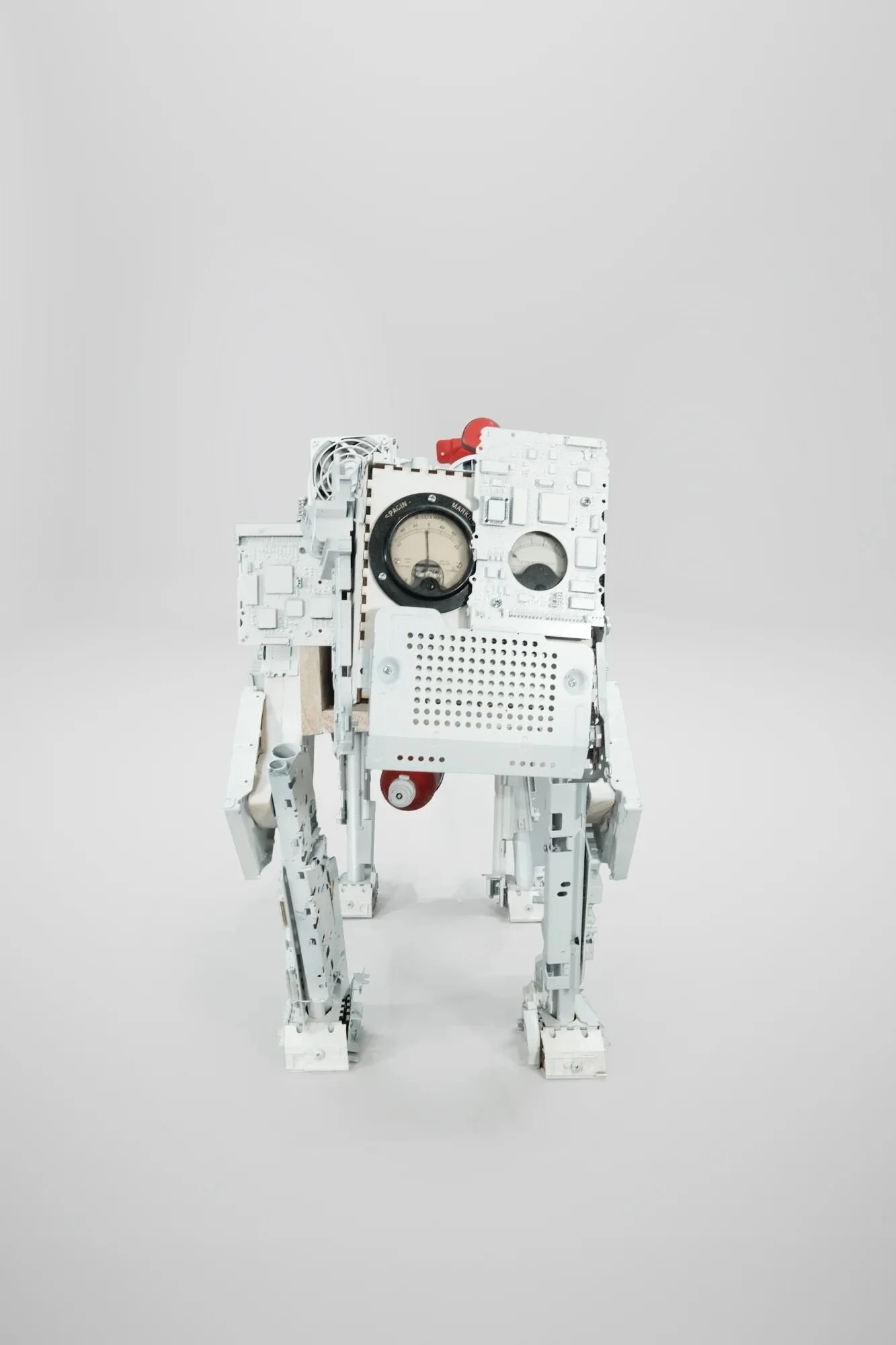 Vintage amperage gauges as eyes—needle displays reading simultaneously as sensor arrays and organic eyes. Intentionally dormant, tilted, watching