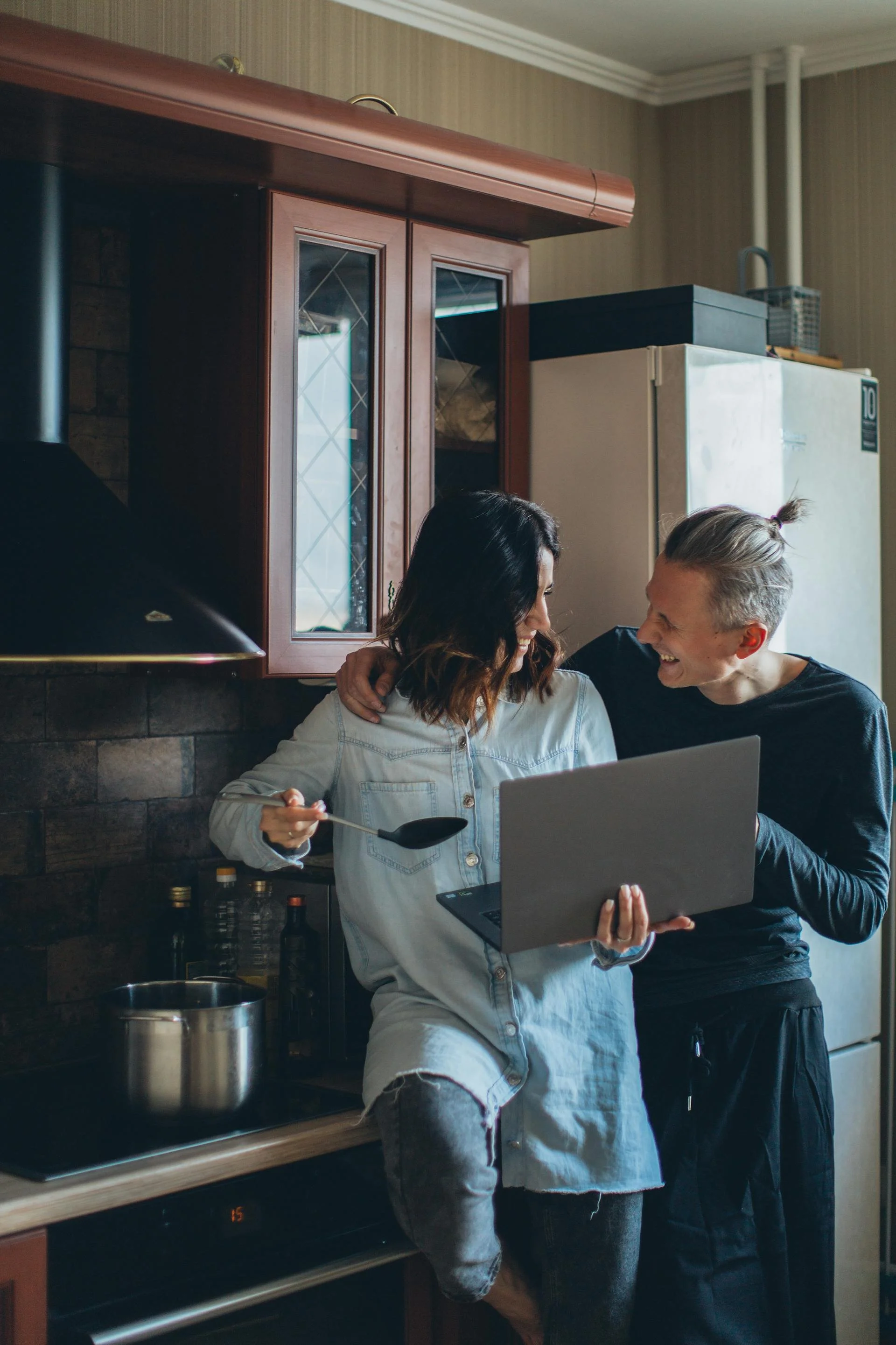 A couple cooking together happily celebrating the decision to get a vasectomy in Victoria, BC at Victoria Men's Health Clinic.