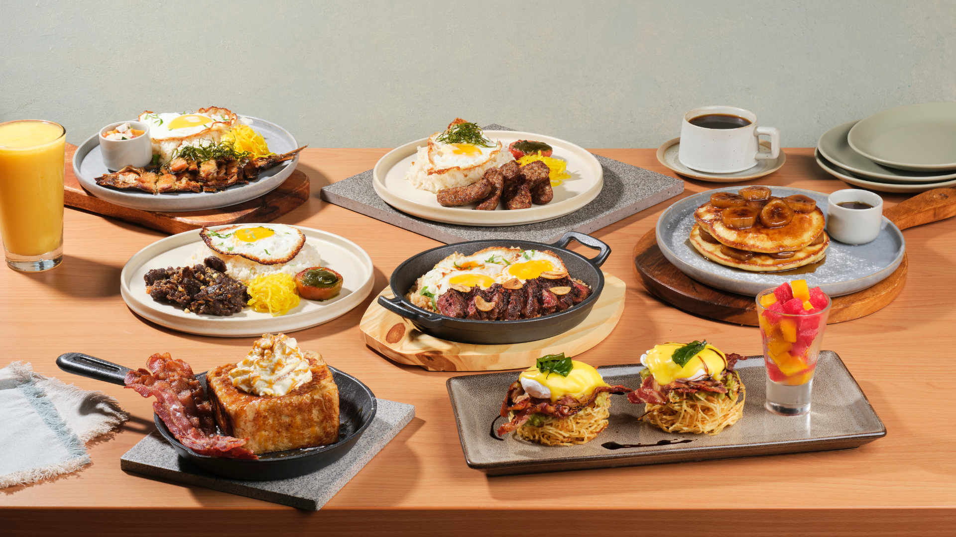 Table of Dempsey brunch dishes, including Garlic Steak & Eggs, Tres Leches French Toast, Eggs Benny Crunch, Brown Butter Pancakes, Longganisa Recado, Angus Tapa, and House-Smoked Bangus