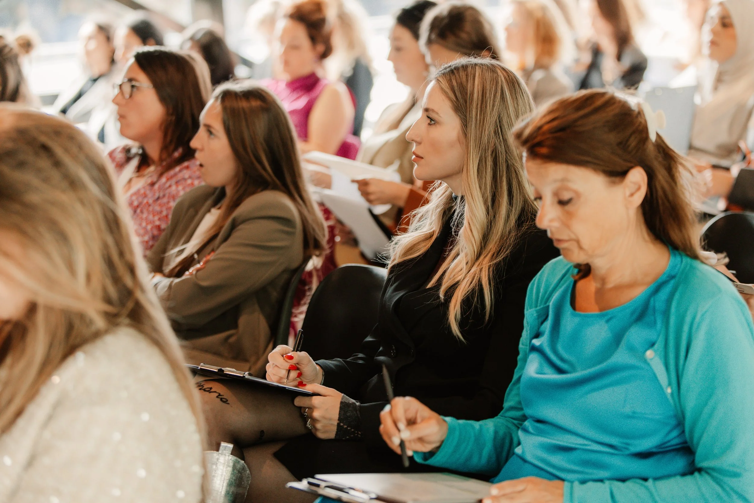 Publiek maakt notities bij presentatie