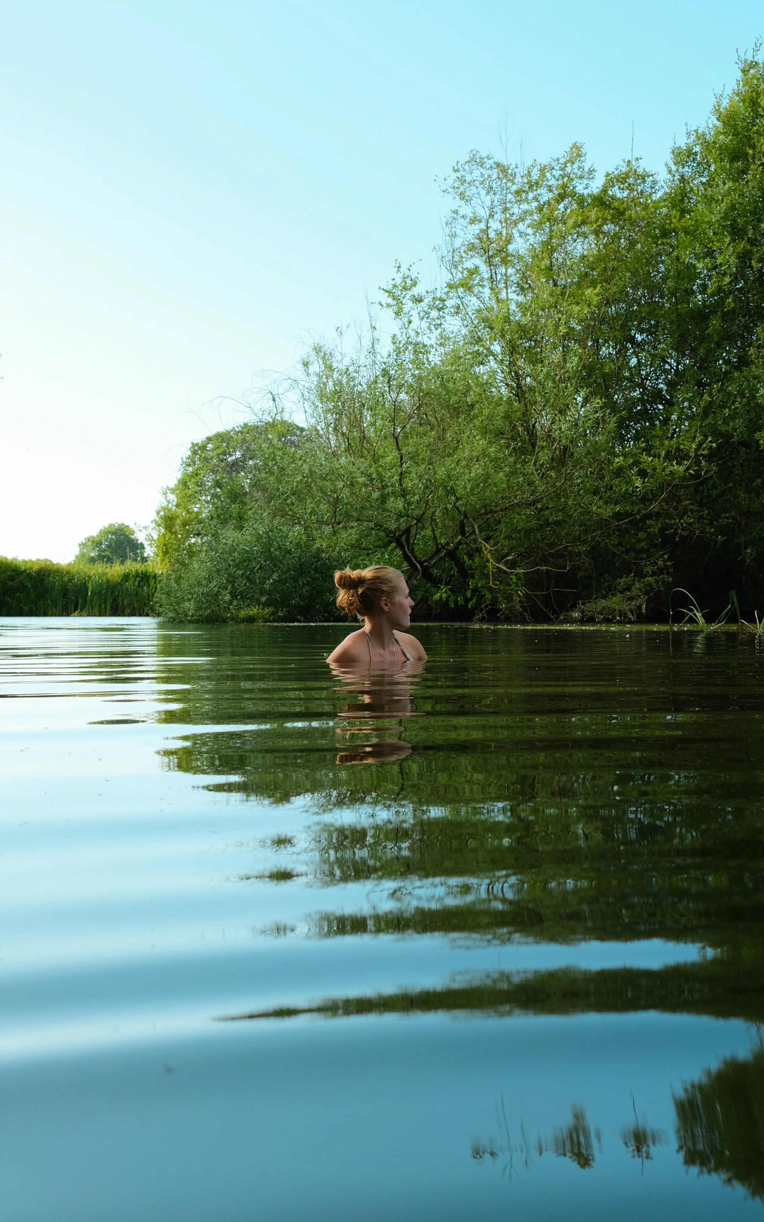 A young lady in a wild swimming pond 