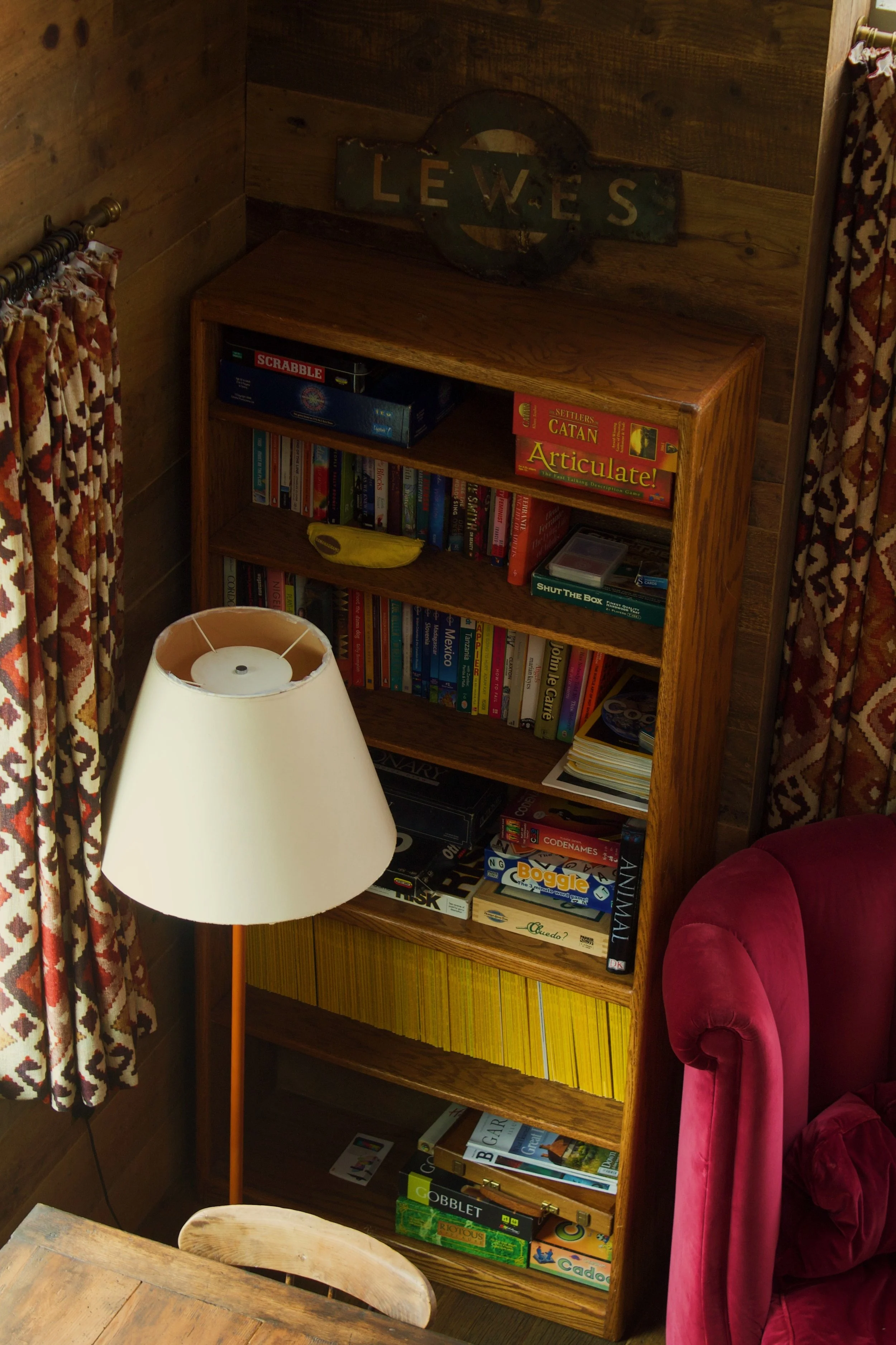 A bookshelf full of books and games in a Sussex cabin 