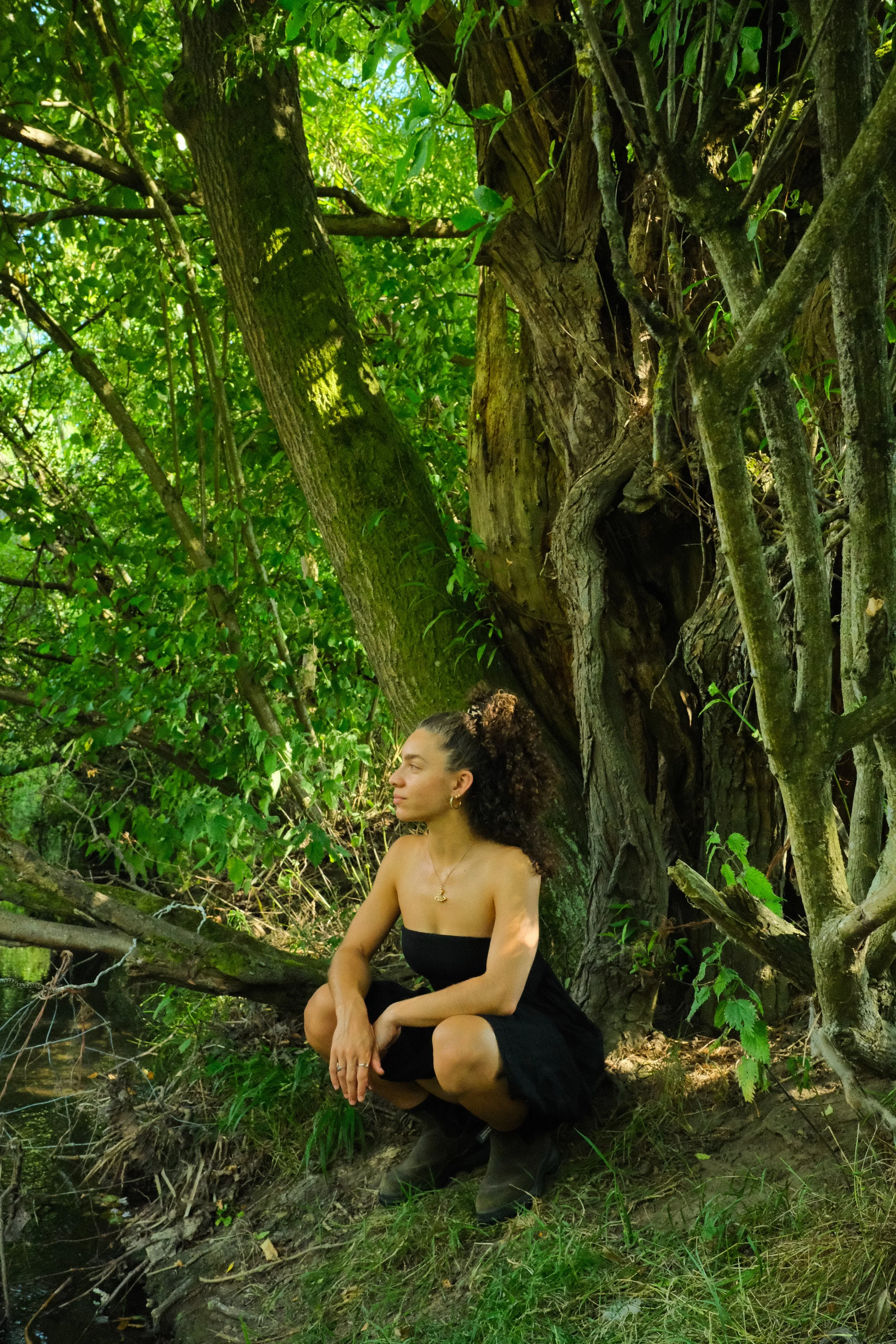 A lady sitting under a tree in the countryside