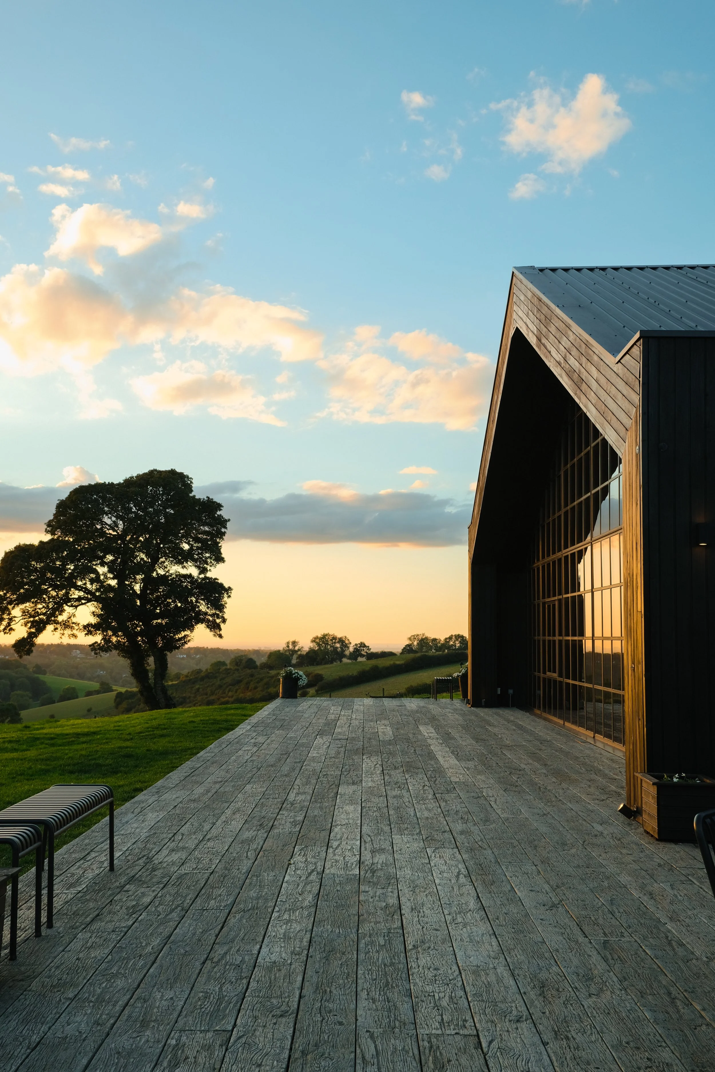 A black cladded barn during sunset