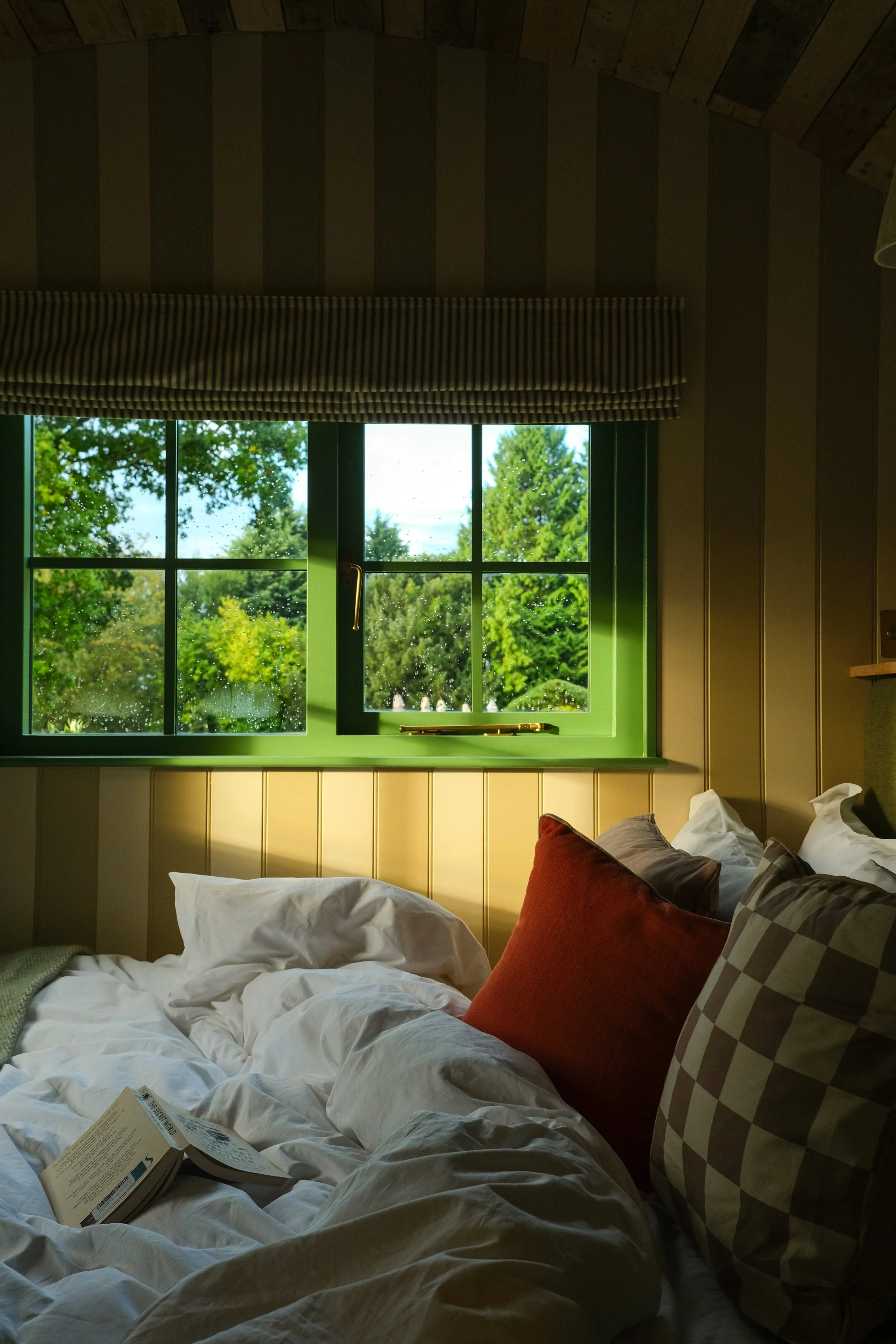 Morning sunshine on a bed inside a shepherds hut in the countryside