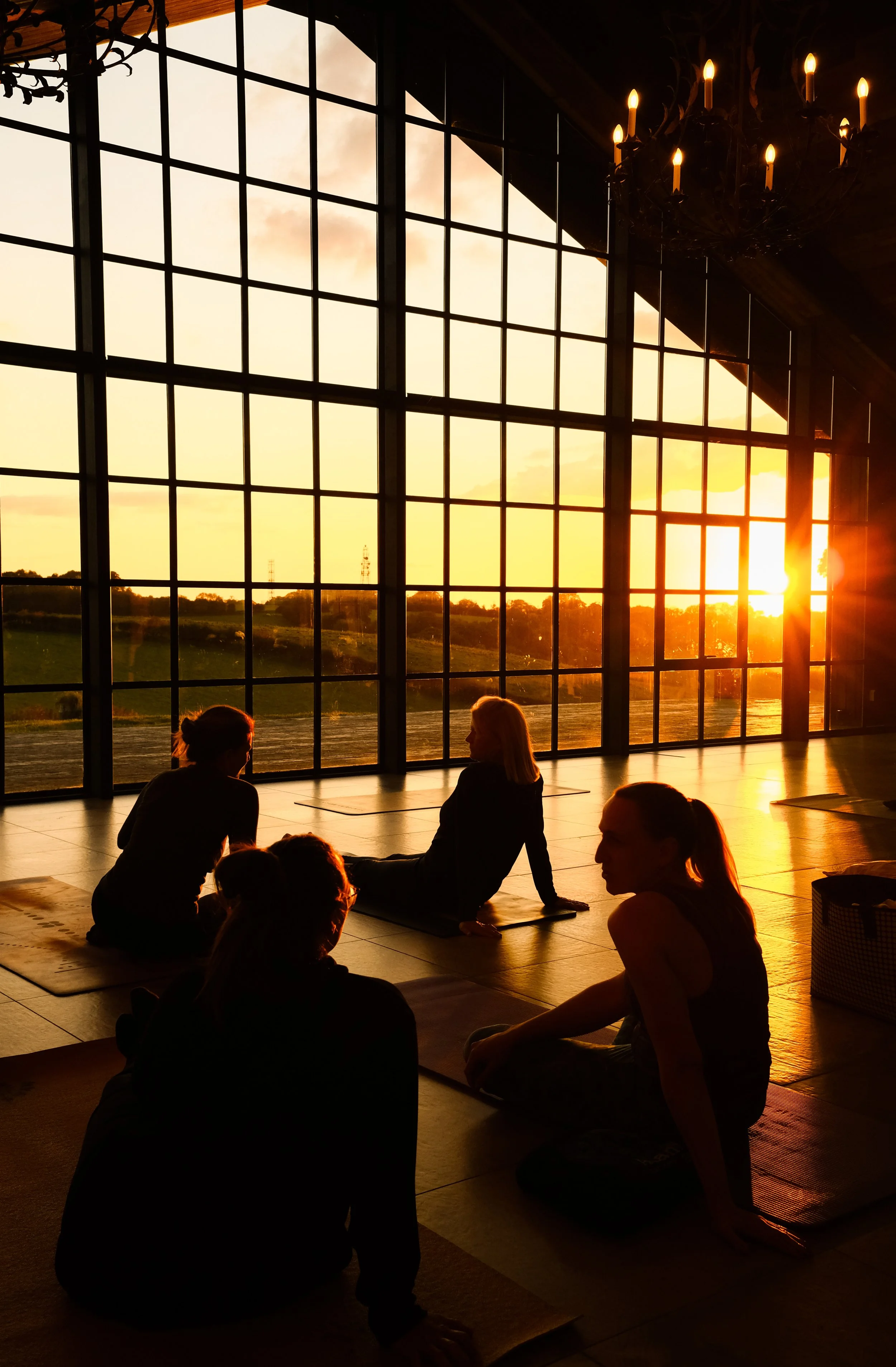 Ladies sitting in a barn for a pilates class during sunset