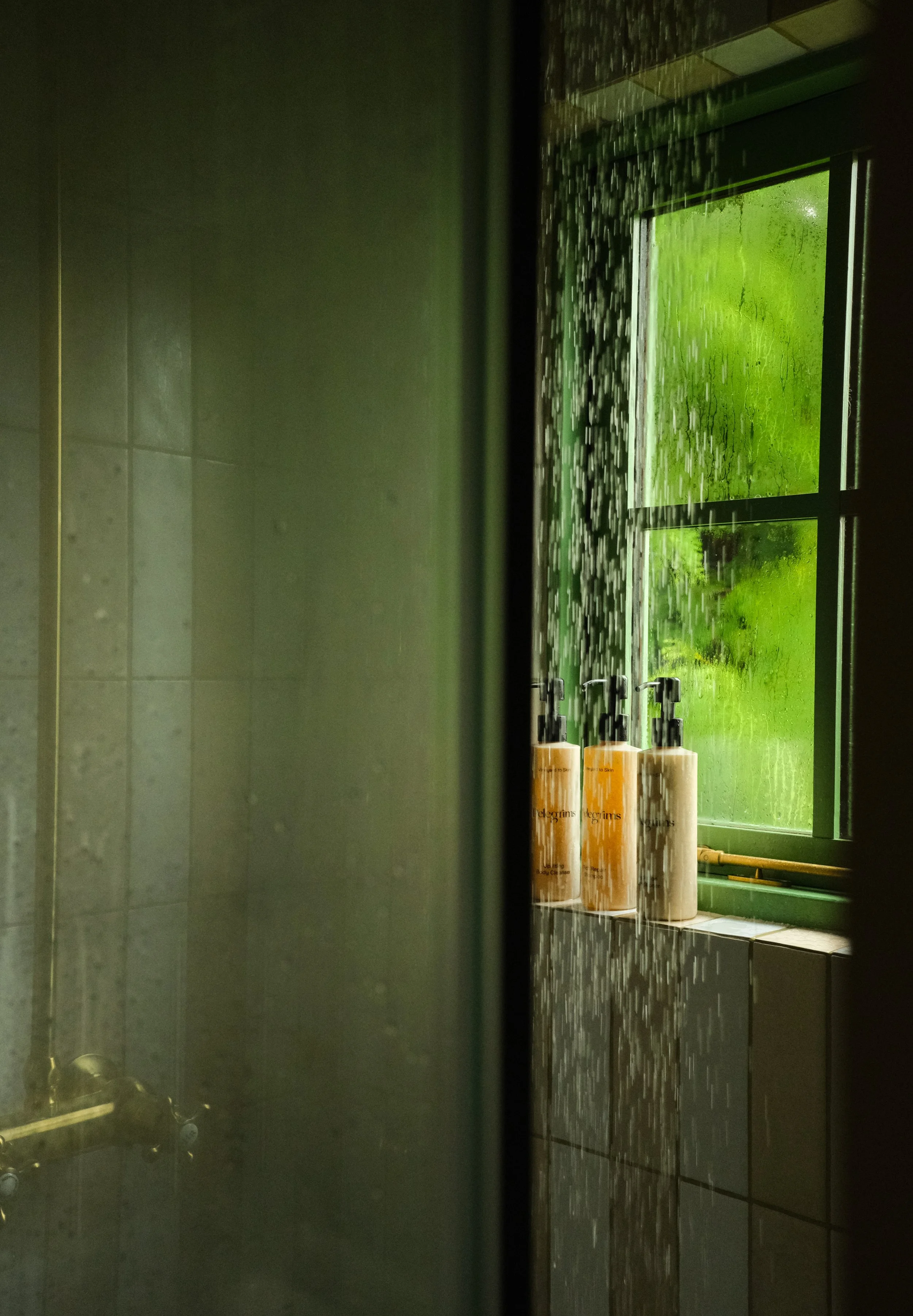 A shower running in a stylish shepherds hut bathroom during low light