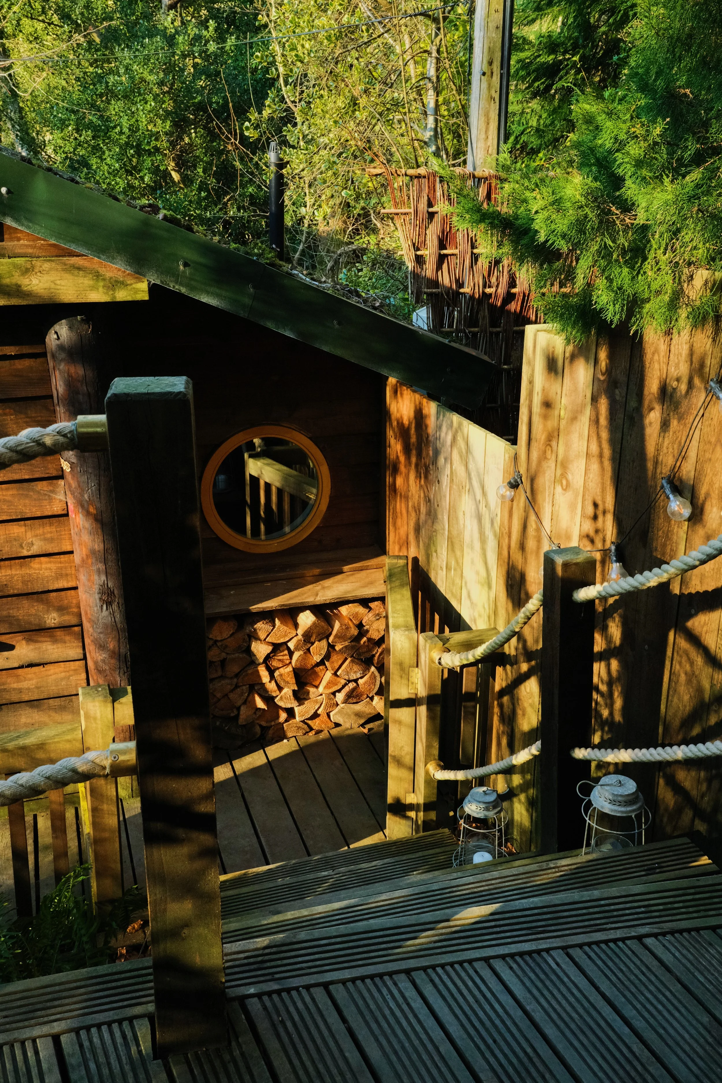 Logs stacked outside a wooden cabin with sun golden sunset sun shining on them