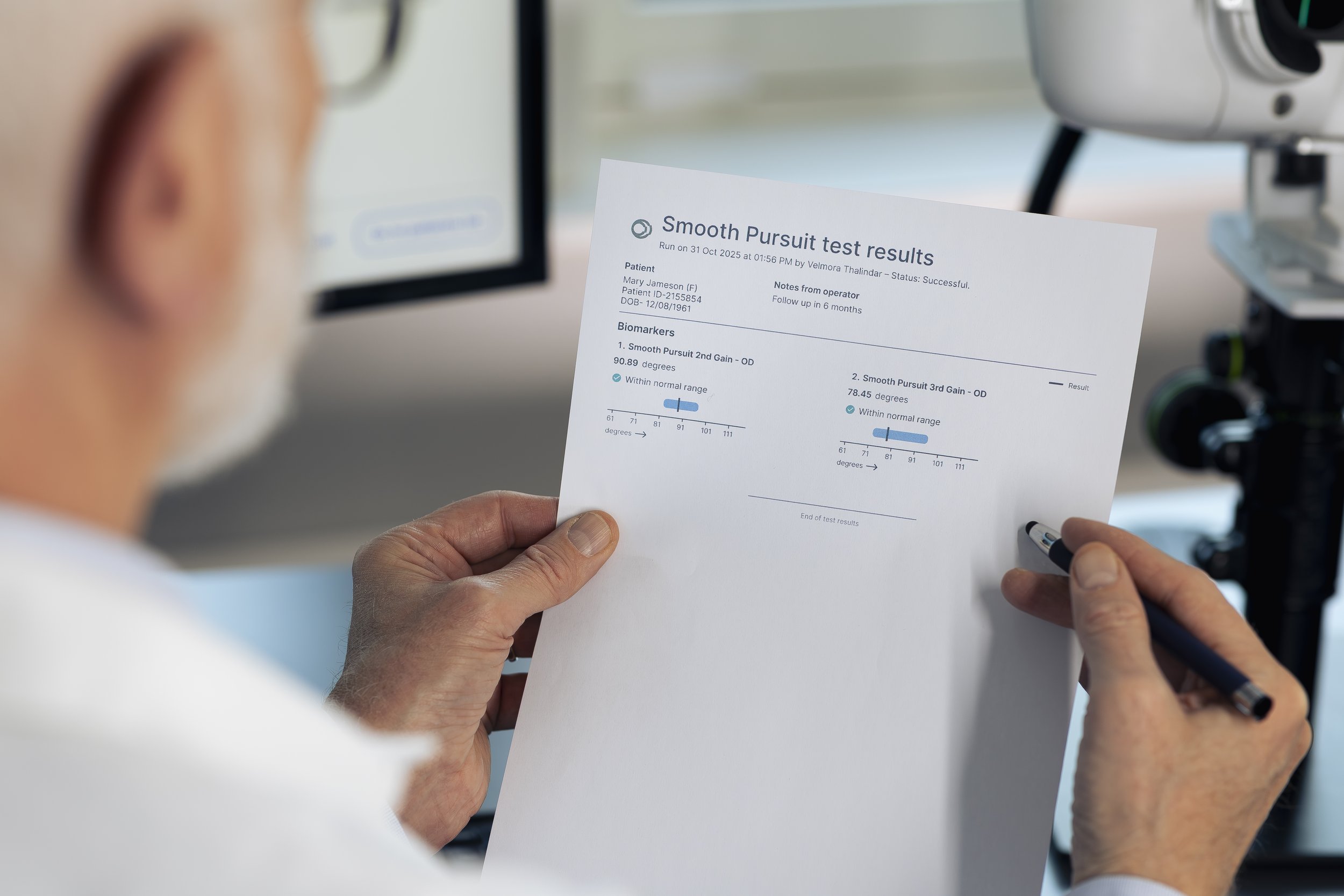A person holding a medical test results paper titled 'Smooth Pursuit test results' with graphs and medical data, in a clinical setting equipped with a microscope and computer screens.