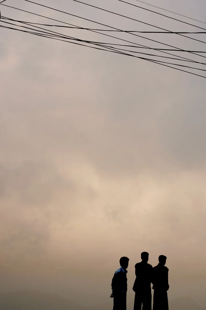 3 hommes Sri Lankais en silhouette sur un fond de ciel nuageux. Au coucher du soleil. 