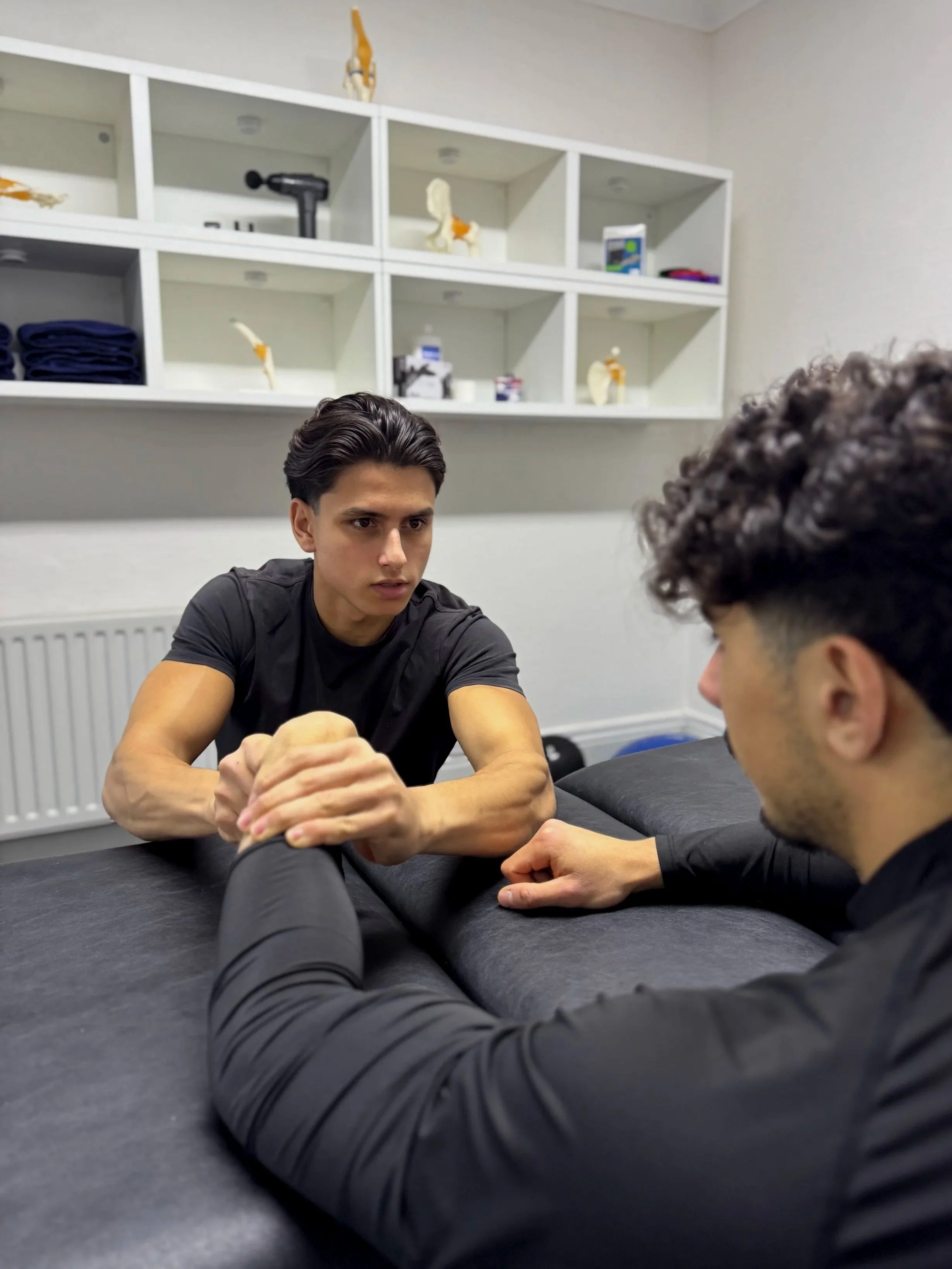 A sport therapist assessing a patient during a consultation