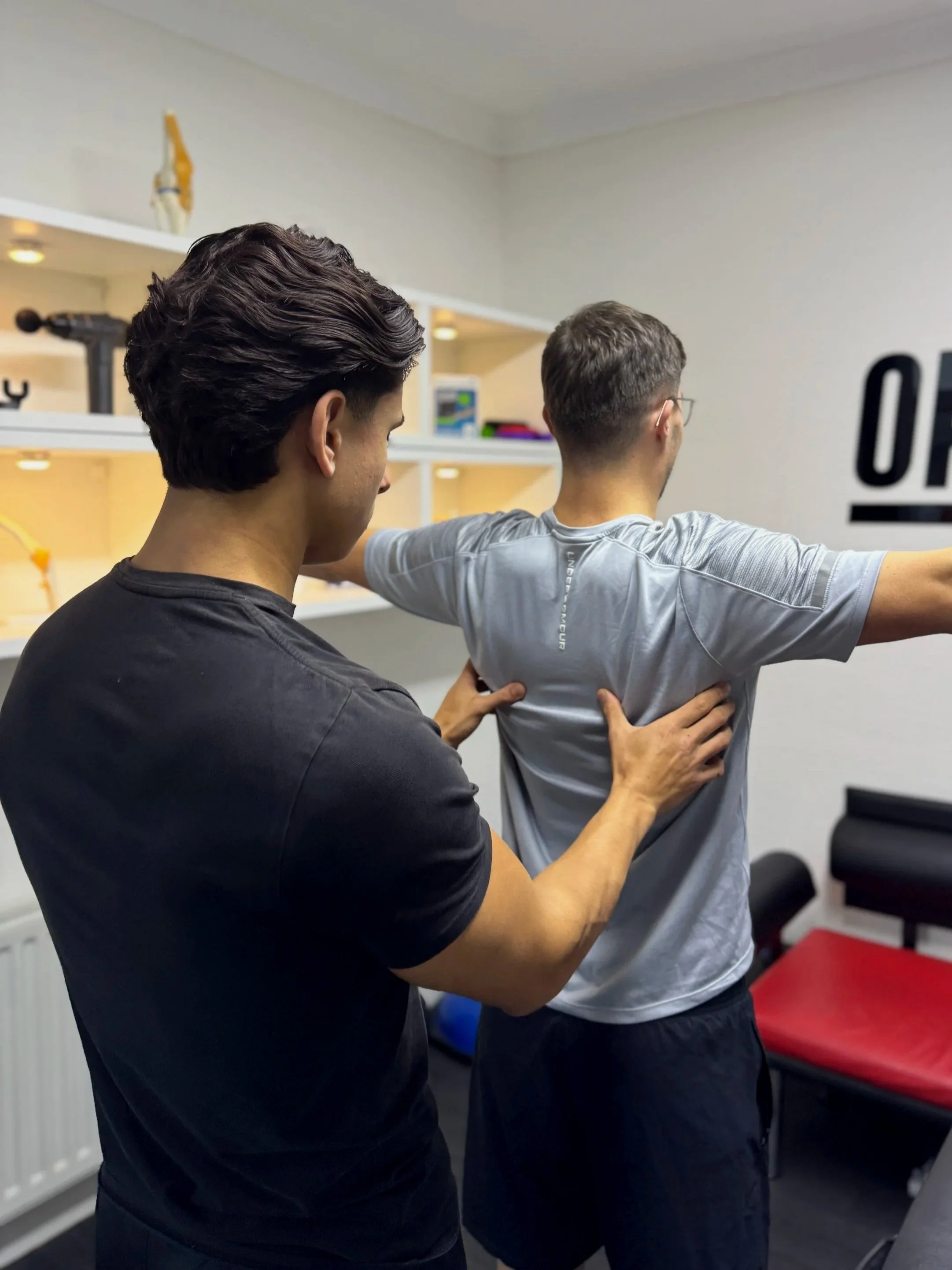 A sport therapist assessing a patient during a consultation