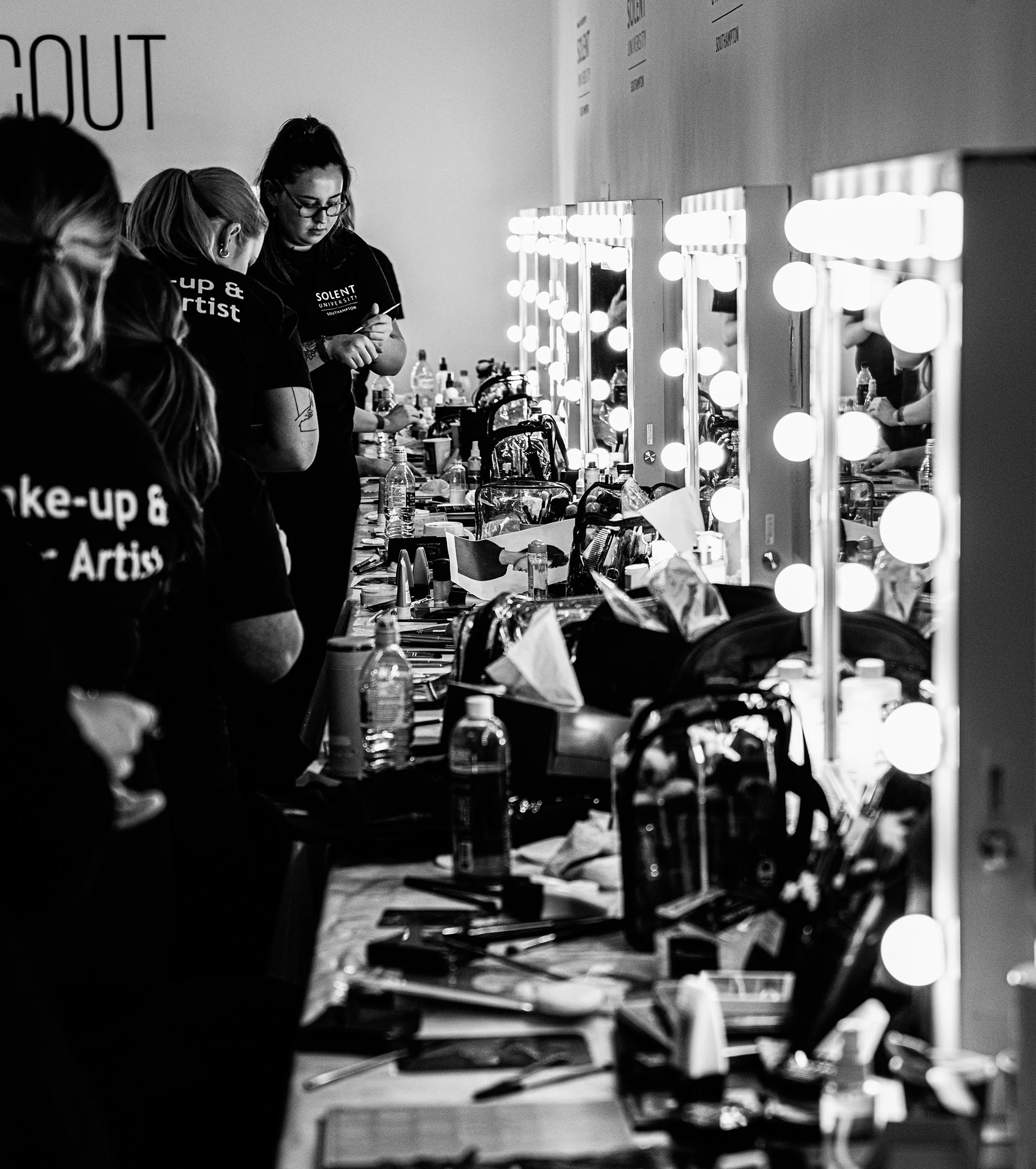 Backstage makeup artists preparing models before a fashion show