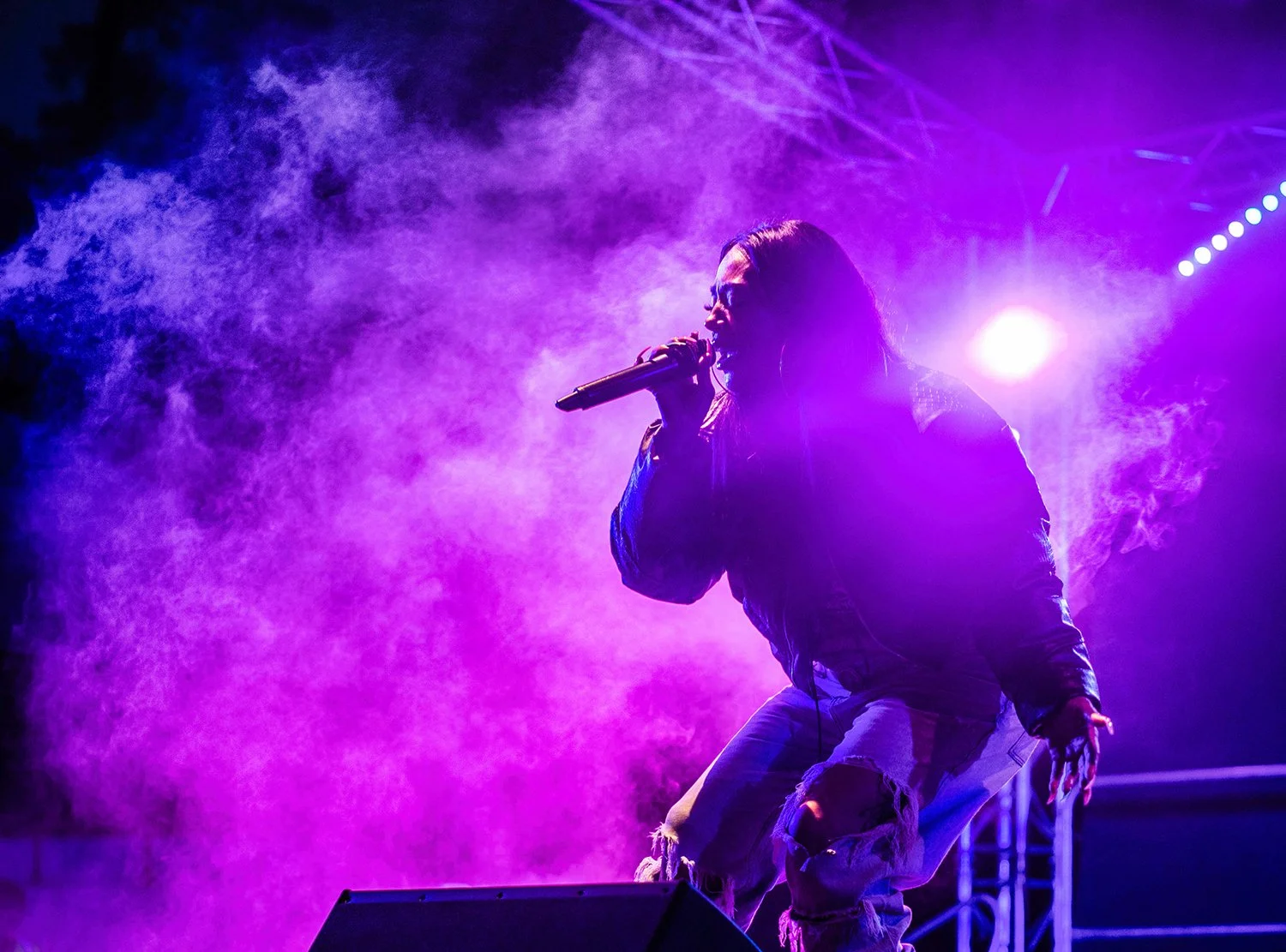 Festival headline singer on stage in dramatic lighting