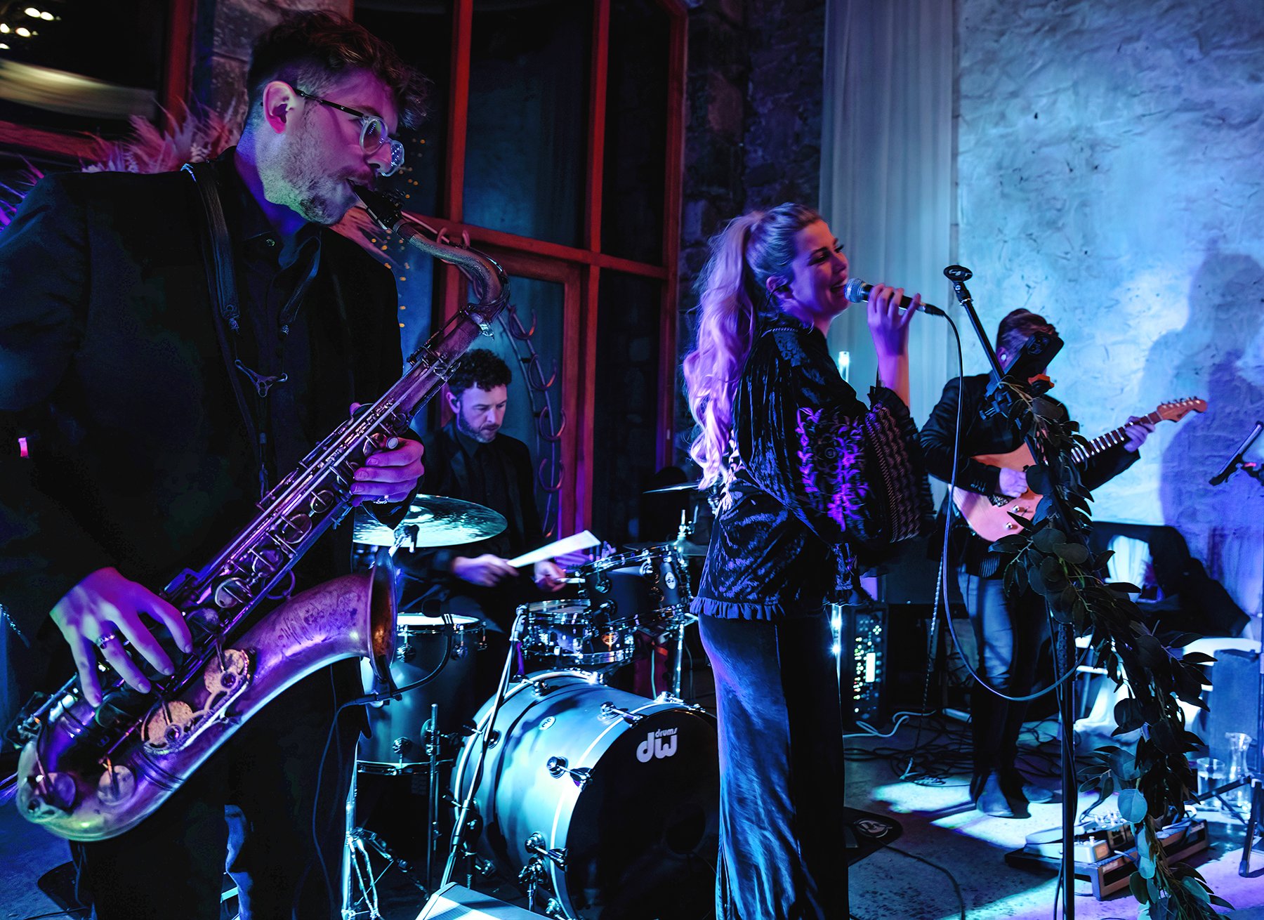 Live band performing under festoon lights at an evening event