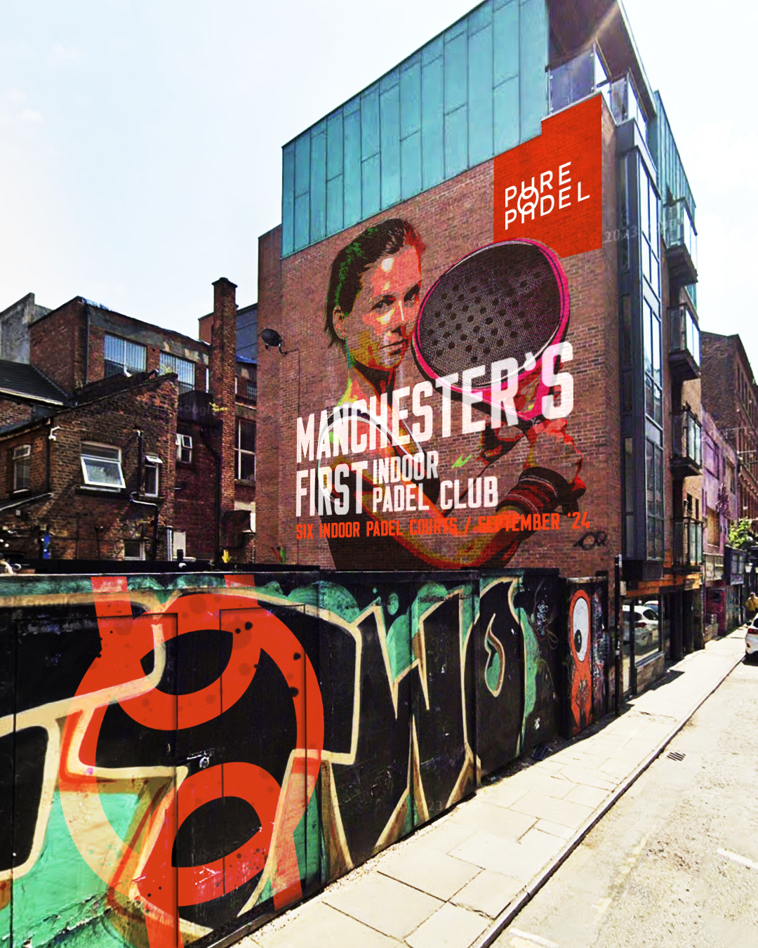 A mural on a brick building advertises Manchester's first indoor padel club, with text mentioning six indoor courts opening in September 2024, featuring artwork of a woman holding a padel racket.