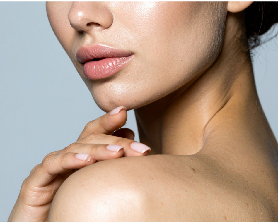 Close-up of a woman's face, hand on shoulder, showing smooth skin and natural makeup.