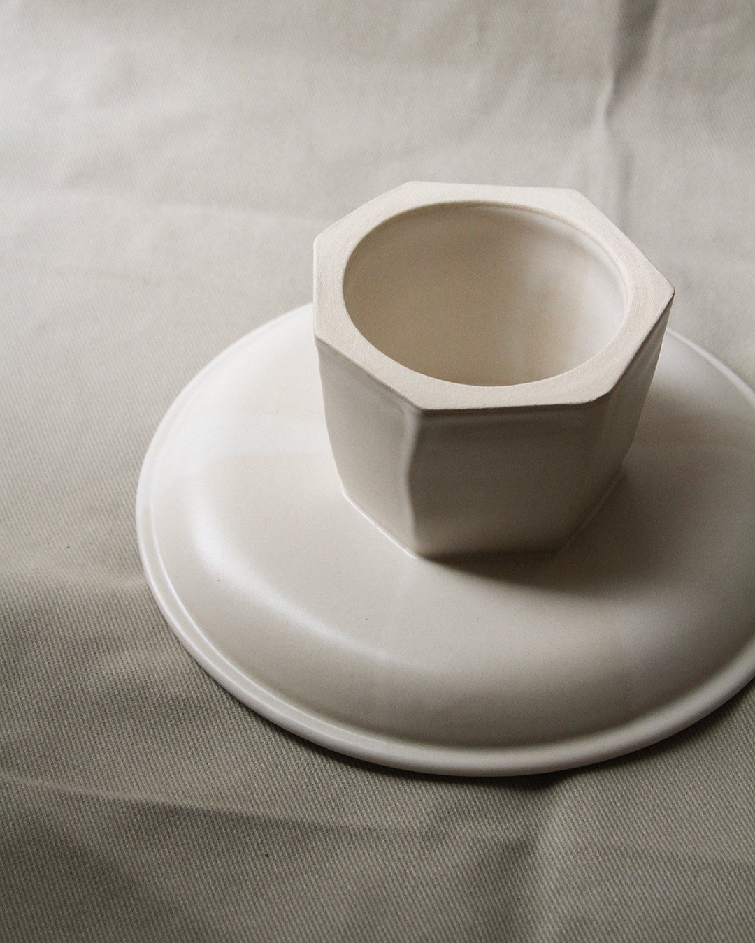 An upside-down pedestal plate with a detail of the faceted column