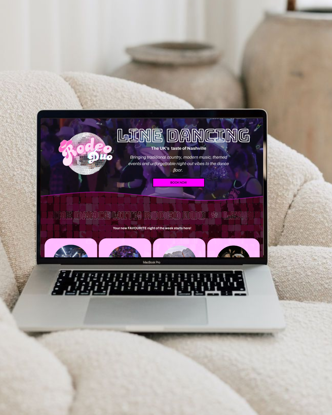 Laptop on a white textured couch displaying a website for line dancing events with a pink and purple theme, featuring a disco ball logo and a "Book Now" button.