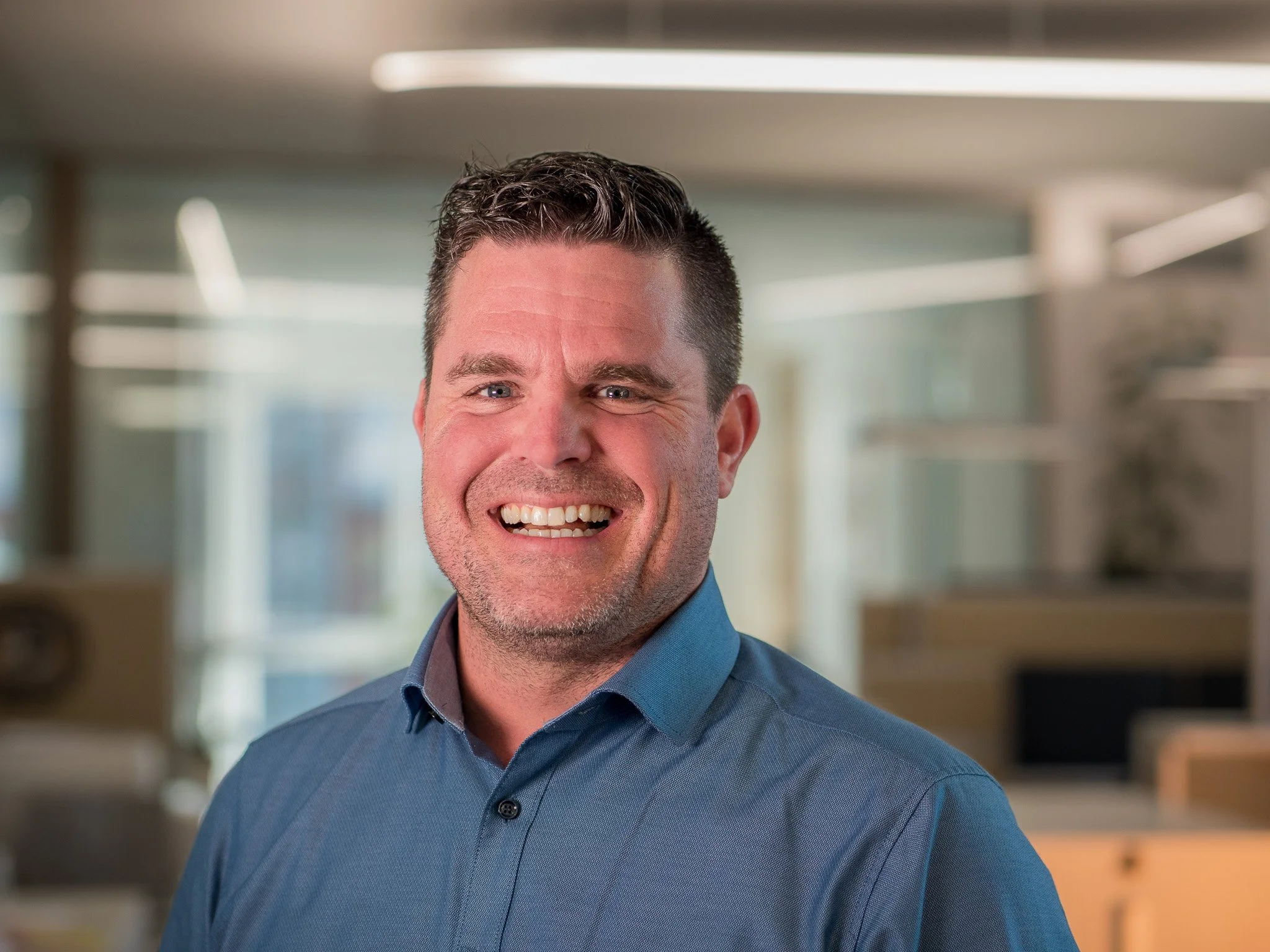 Lächelnder Mann mit blauer Hemd im Büro