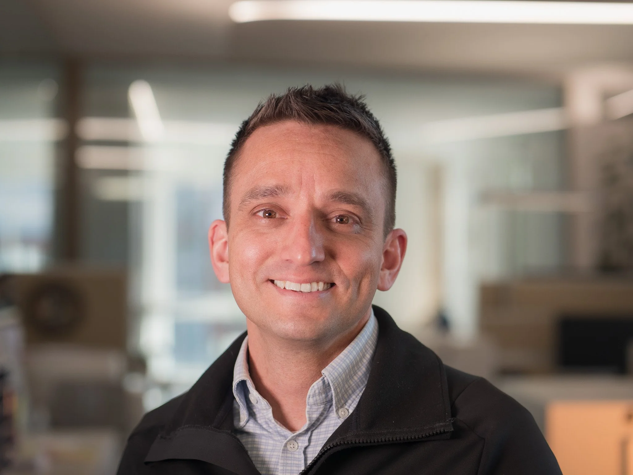 Lächelnder Mann in einem Büro mitten im Arbeitstag.