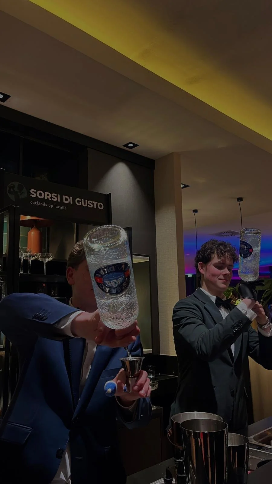 De twee bartenders, van sorsi di gusto, die cocktails maken achter een mobiele bar op een evenement