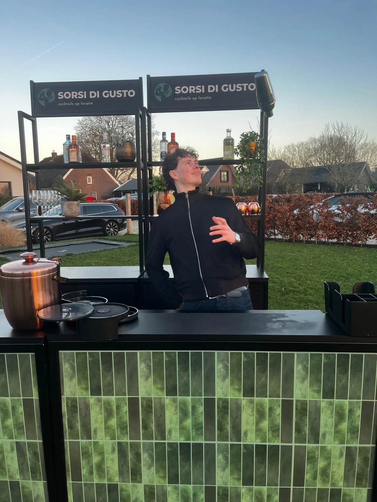 Bartender achter mobiele bar met cocktailshaker. Inklapbare bar en makkelijk mee te nemen.