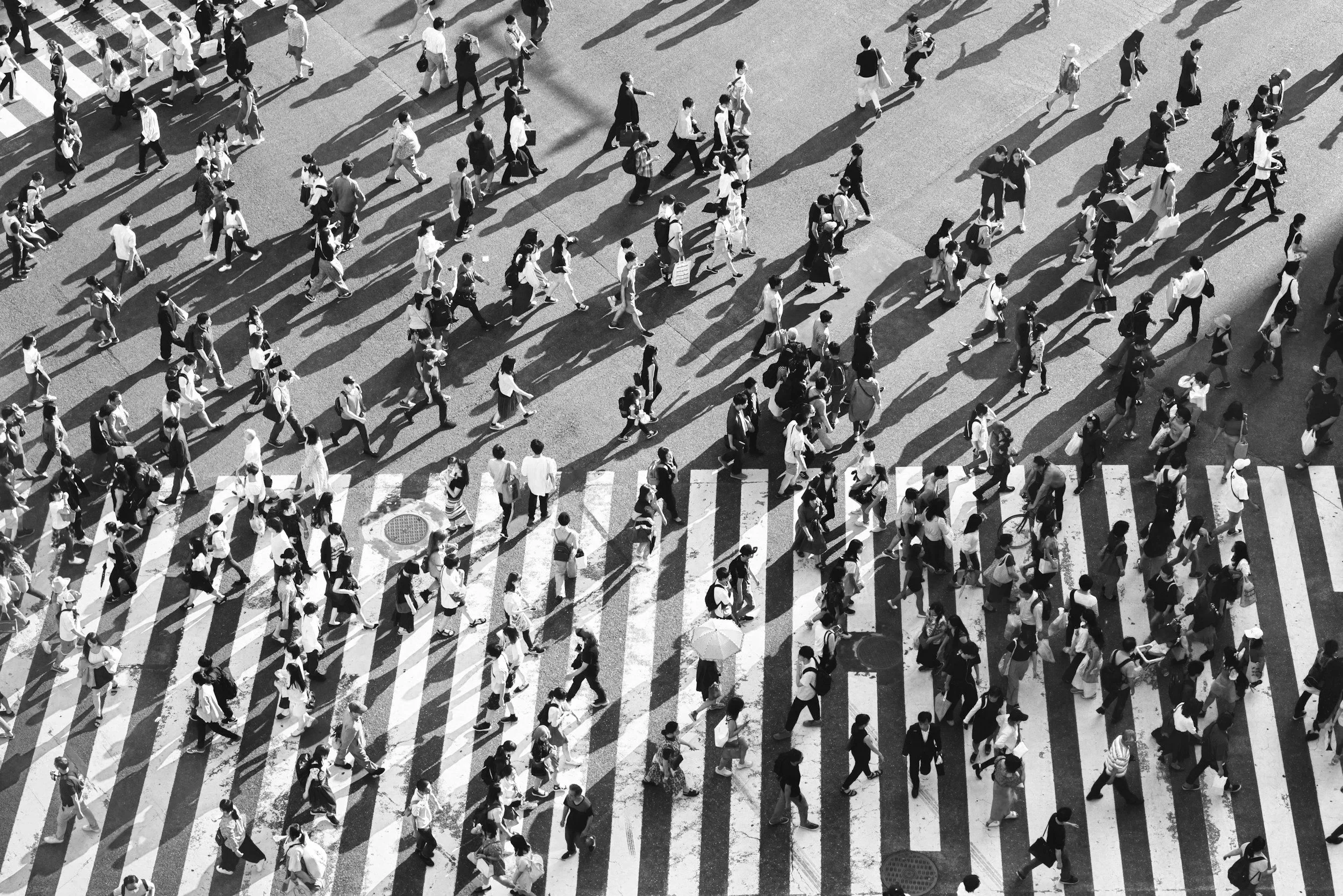 Aerial view of a busy crosswalk with many pedestrians walking in different directions.