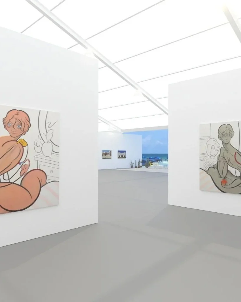 An art gallery with white walls displaying cartoon-style paintings of women, with large windows showing a view of the ocean and blue sky.