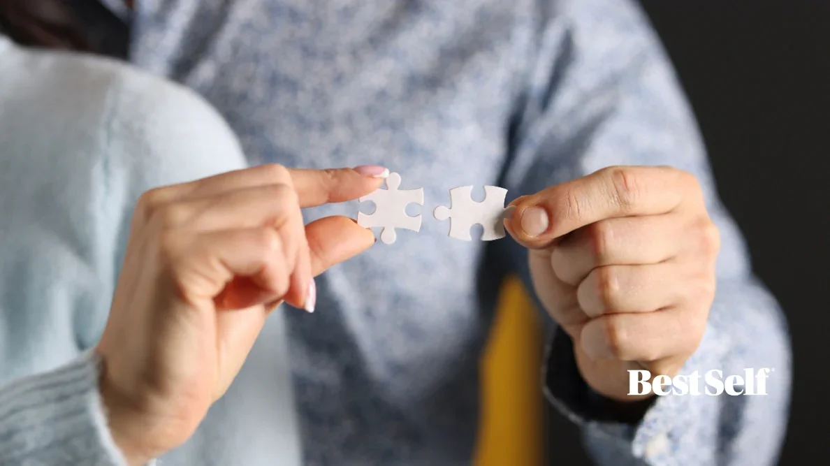 Person connecting two puzzle pieces, emphasizing the idea of fitting or problem-solving, with the text 'BestSelf' in the bottom right corner.