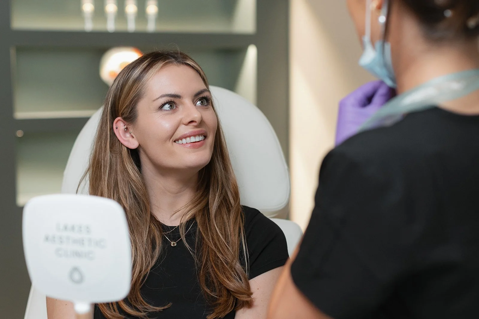 Happy woman receiving facial treatment