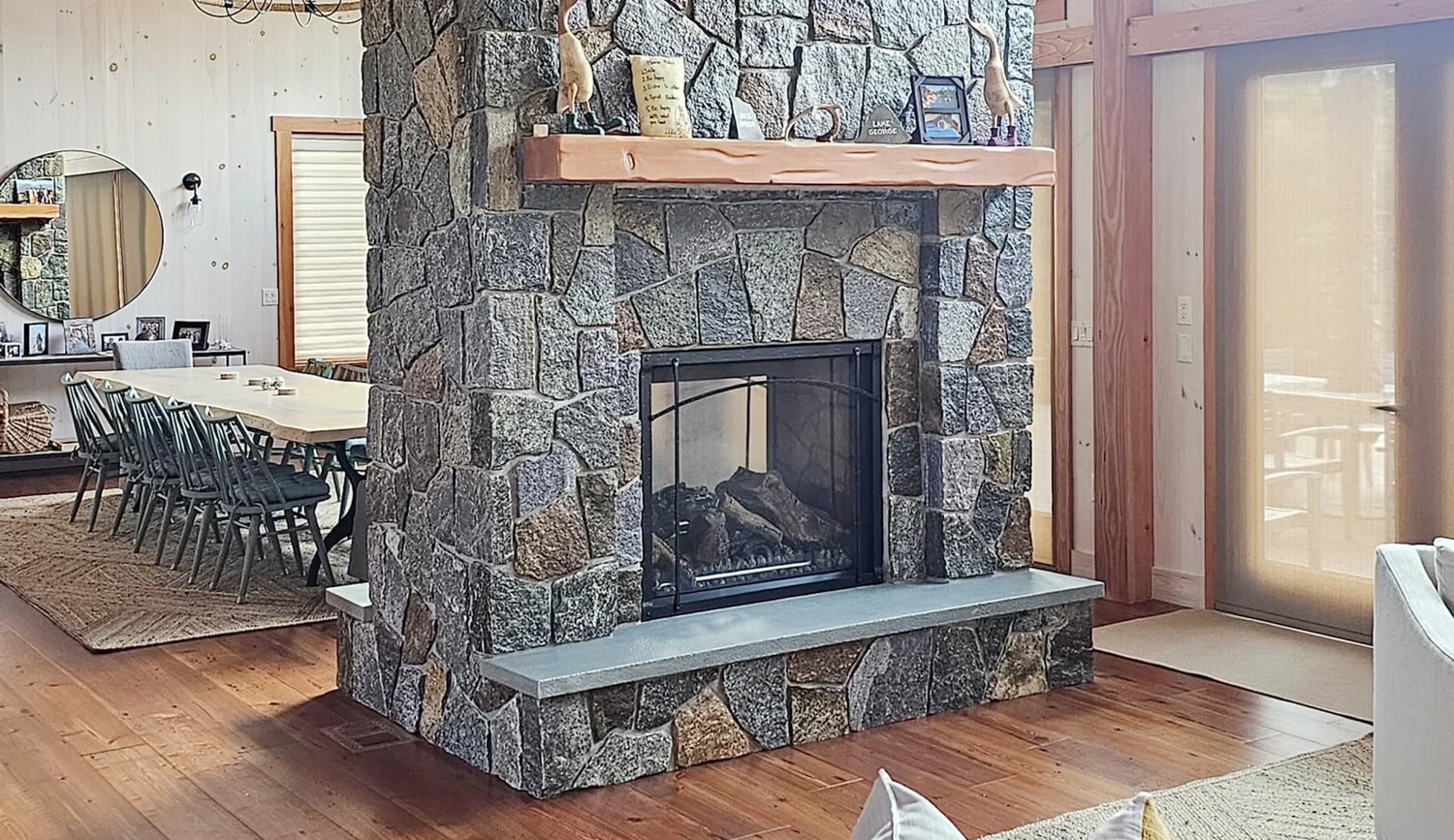 Stone chimney and fireplace under a timber-framed wood ceiling