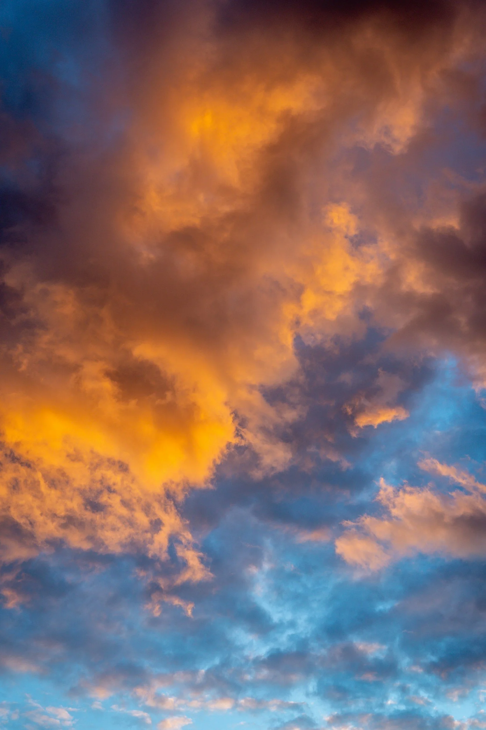 Colorful sky with orange, purple, and blue clouds during sunset or sunrise.