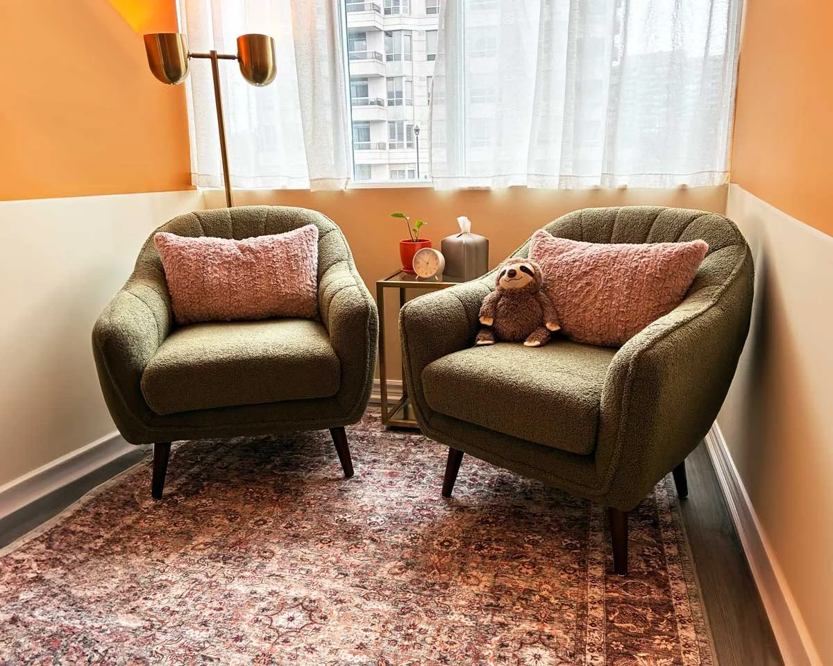two green chairs on a patterned rug in front of a large window