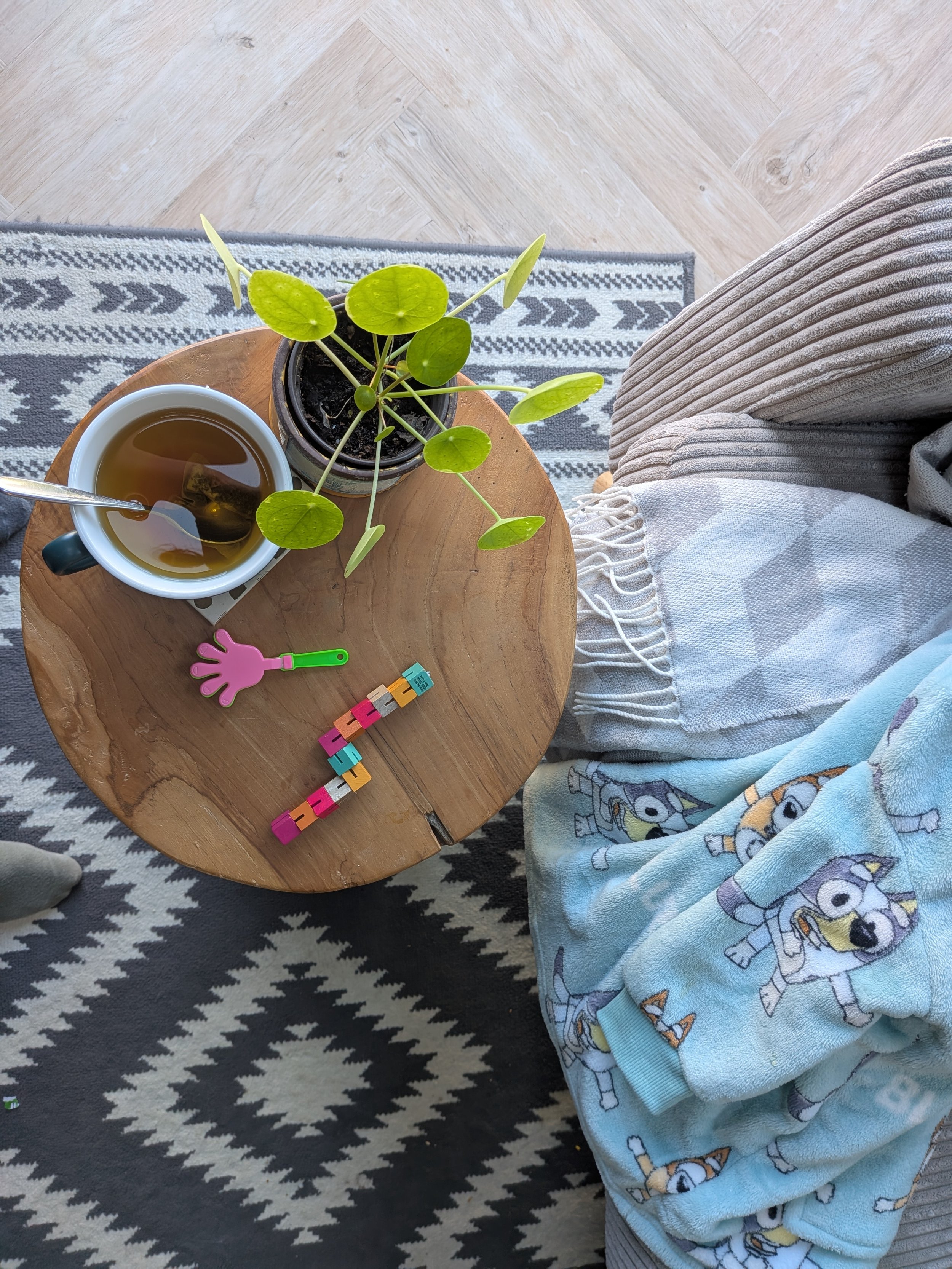 Calming cup of tea at home with toys, banket and plant