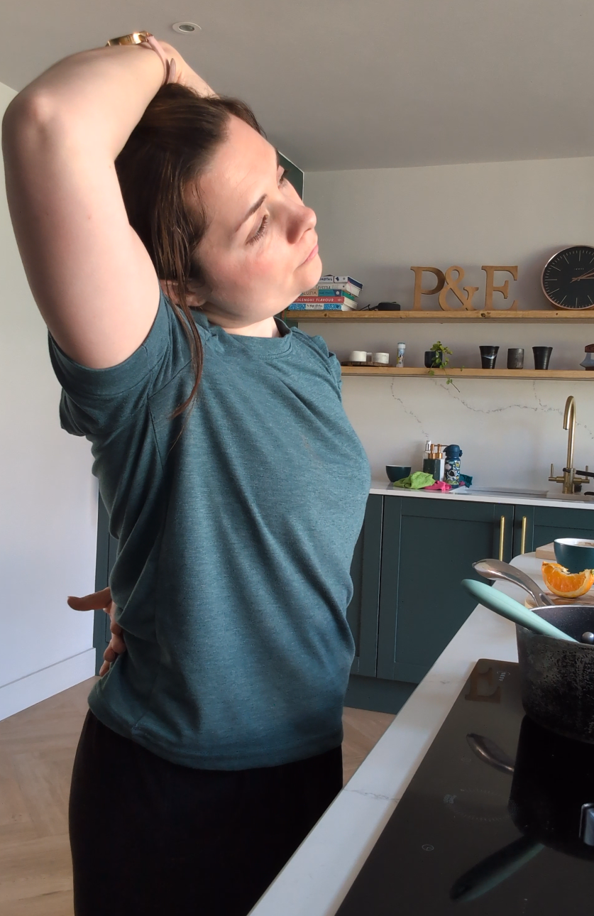 Ellen stretching in kitchen
