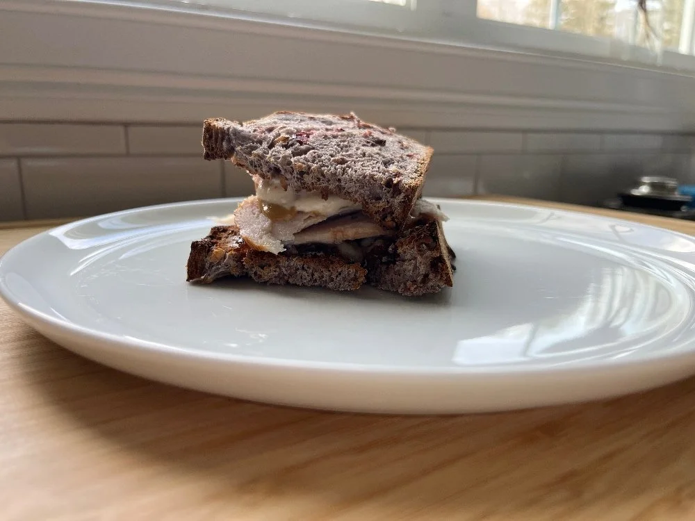 Kirkland oven browned turkey breast on a sandwich on a white plate