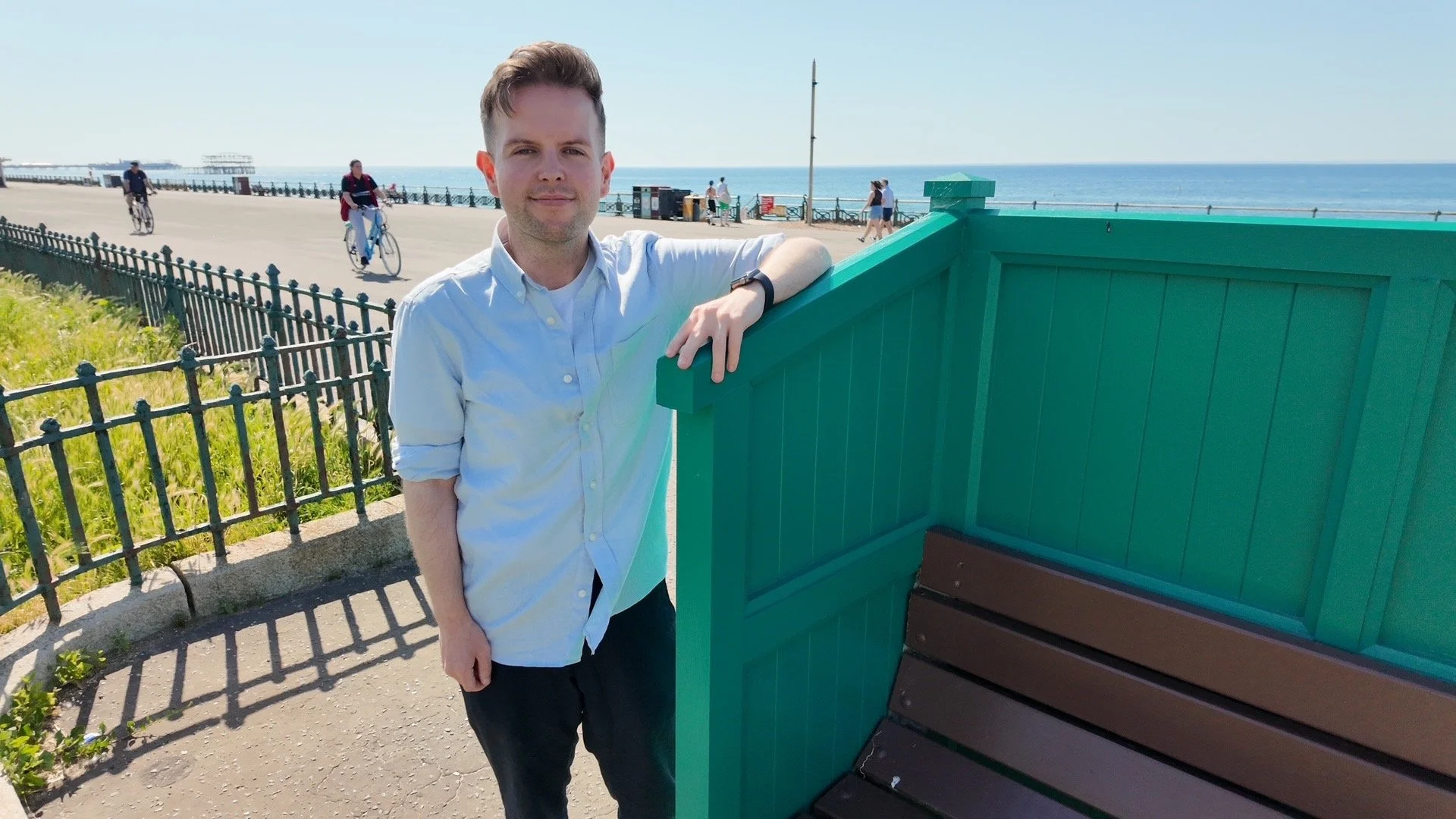 Councillor David McGregor at one of the newly restored cucumber benches on Hove seafront