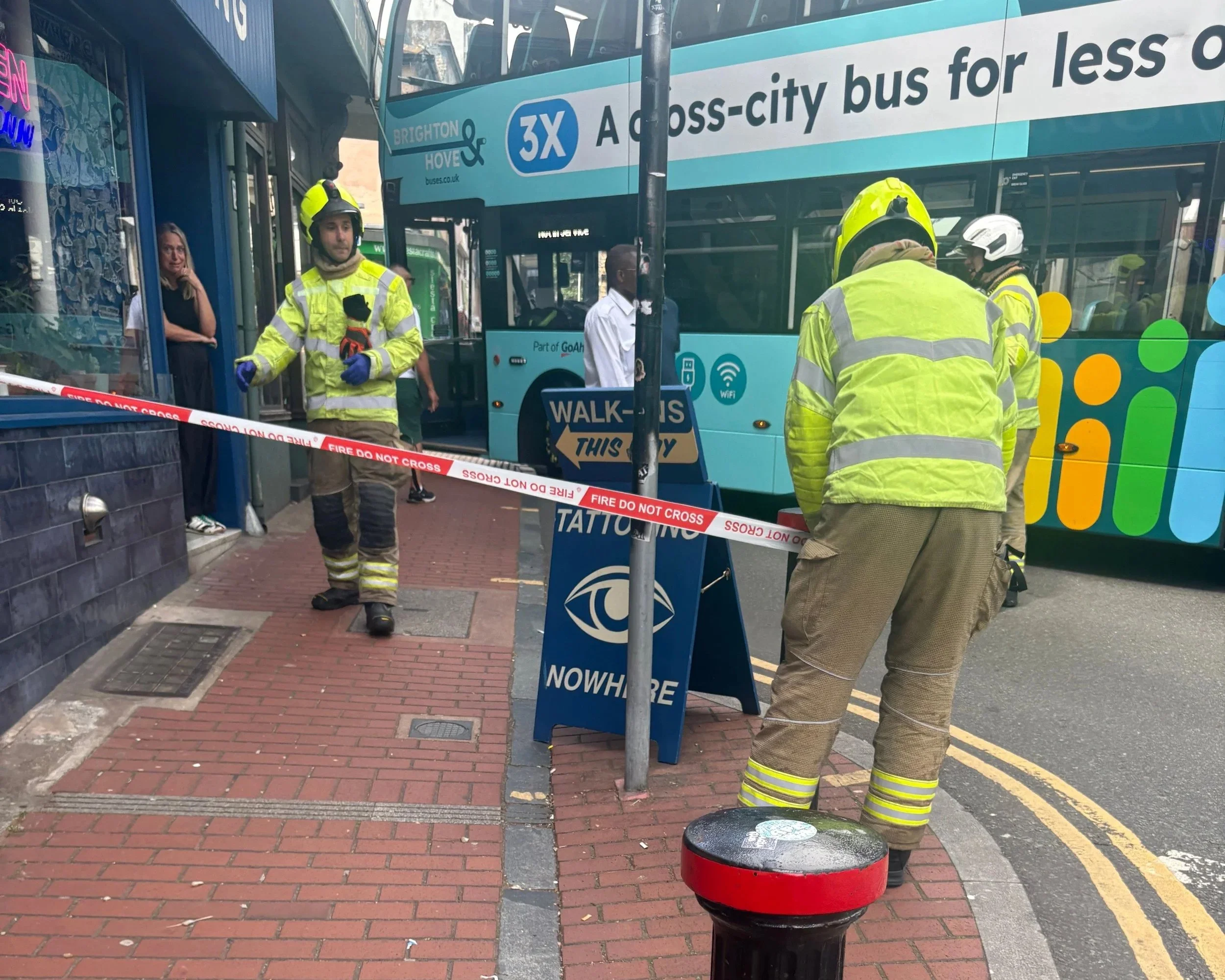 Firefighters at the cordon in front of a Brighton and Hove bus that collided with a shop on Trafalgar Street