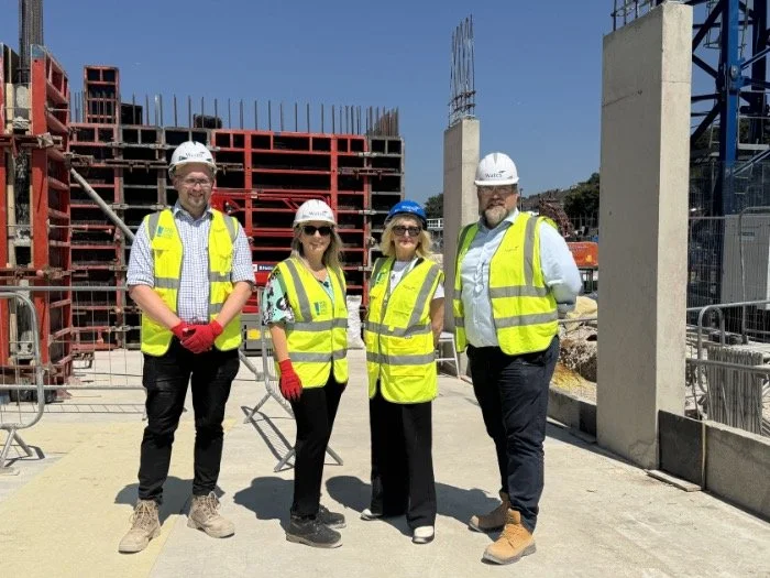Councillor Gill Williams with three members of the Wates Residential team in hi-vis vests and hard hats at the Moulsecoomb development