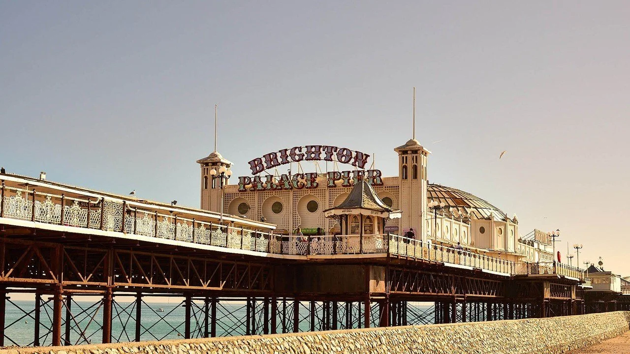 Brighton Palace Pier with its illuminated sign and domed pavilion seen from the seafront on a clear September day