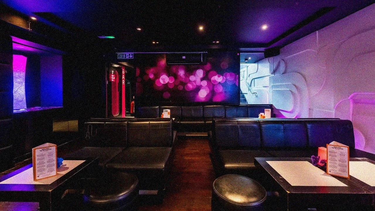 Private karaoke lounge with leather seating and purple lighting at Lucky Voice Brighton