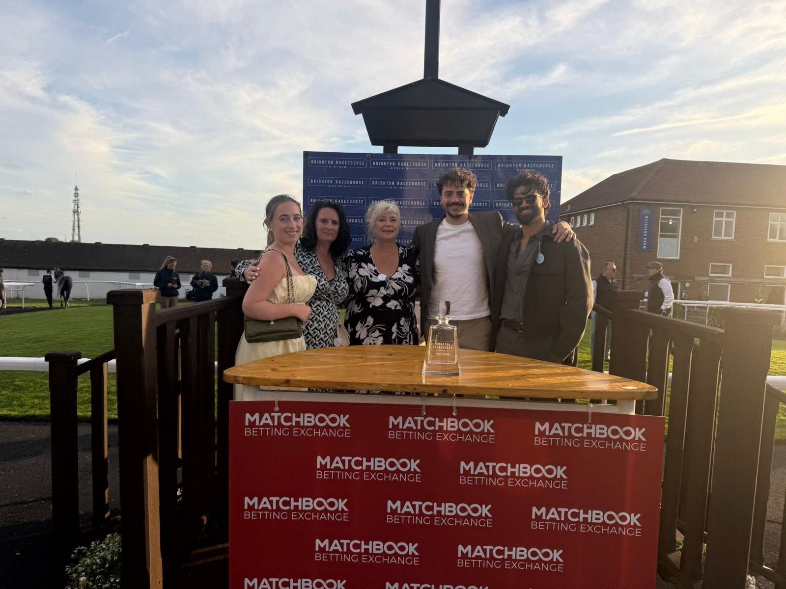 Group of guests posing with the winner's decanter at Brighton Racecourse during Streamline Taxis' Martlets Hospice evening