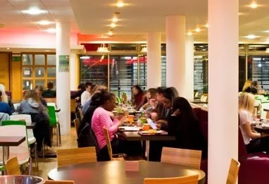 Students eating and socialising in the warm and welcoming cafeteria at University of Brighton Falmer campus