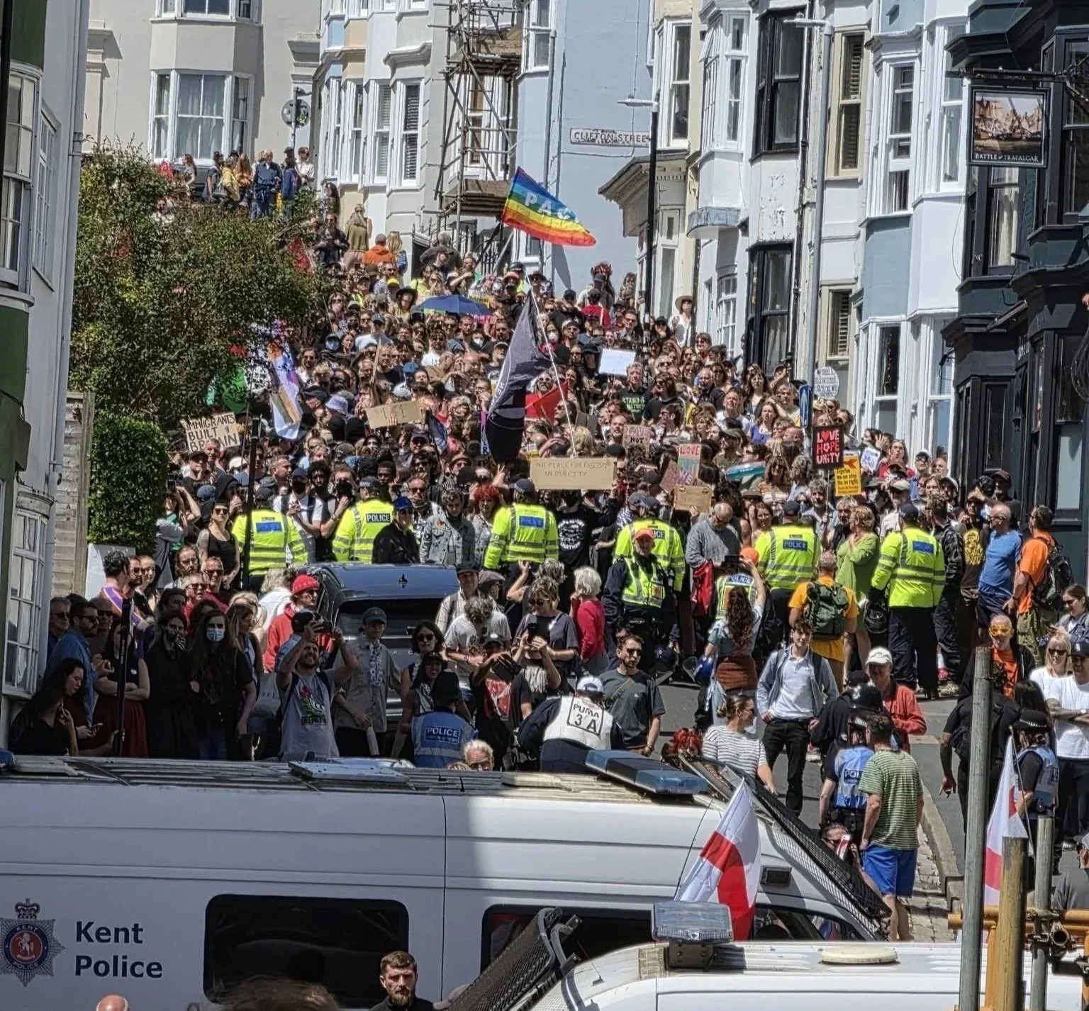 Counter-protesters filling Queens Road in Brighton on 13 June 2026 with police officers and Kent Police van visible