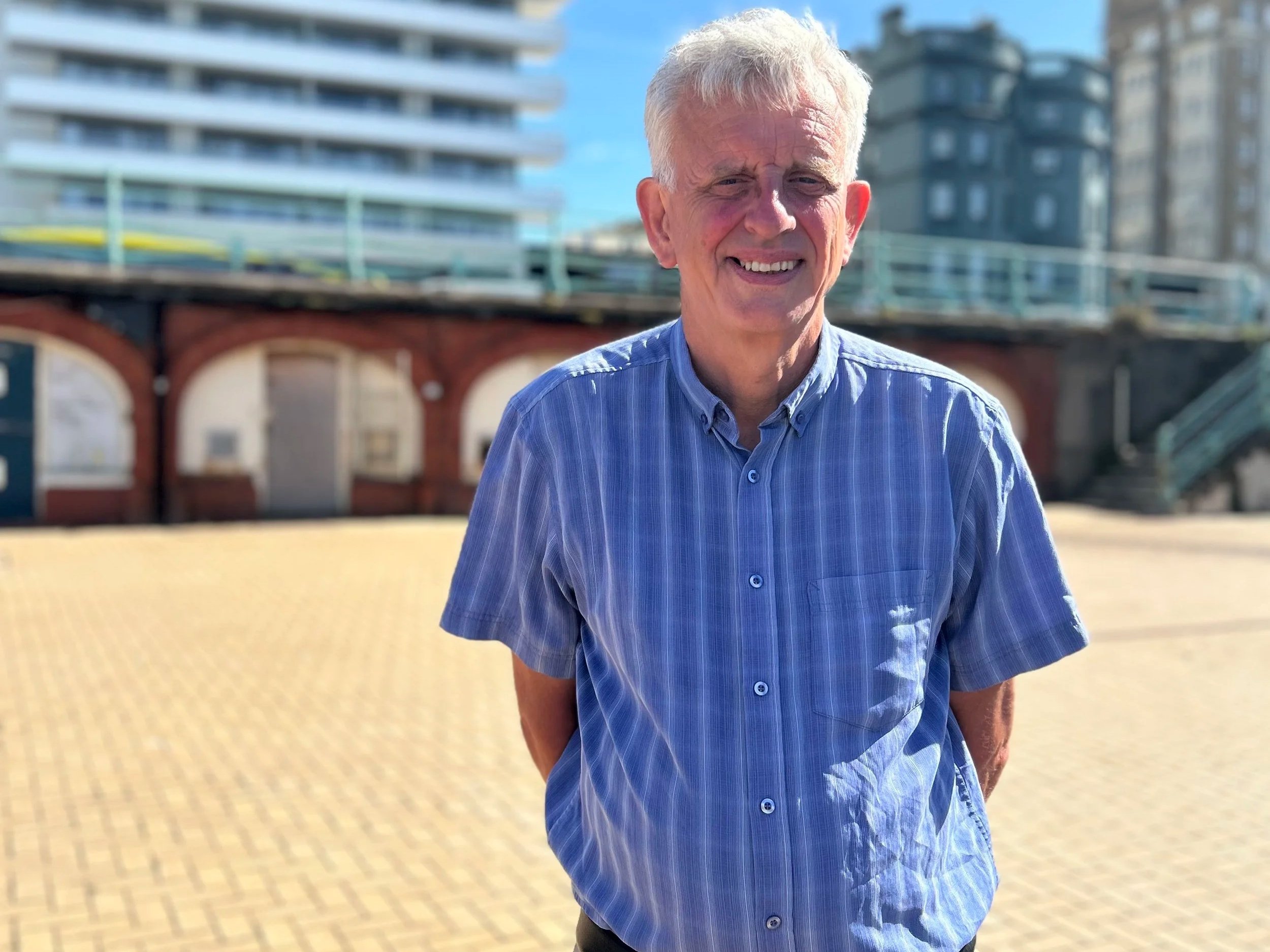 Councillor Trevor Muten, Cabinet Member for Transport and City Infrastructure, standing on Brighton seafront near the King's Road arches