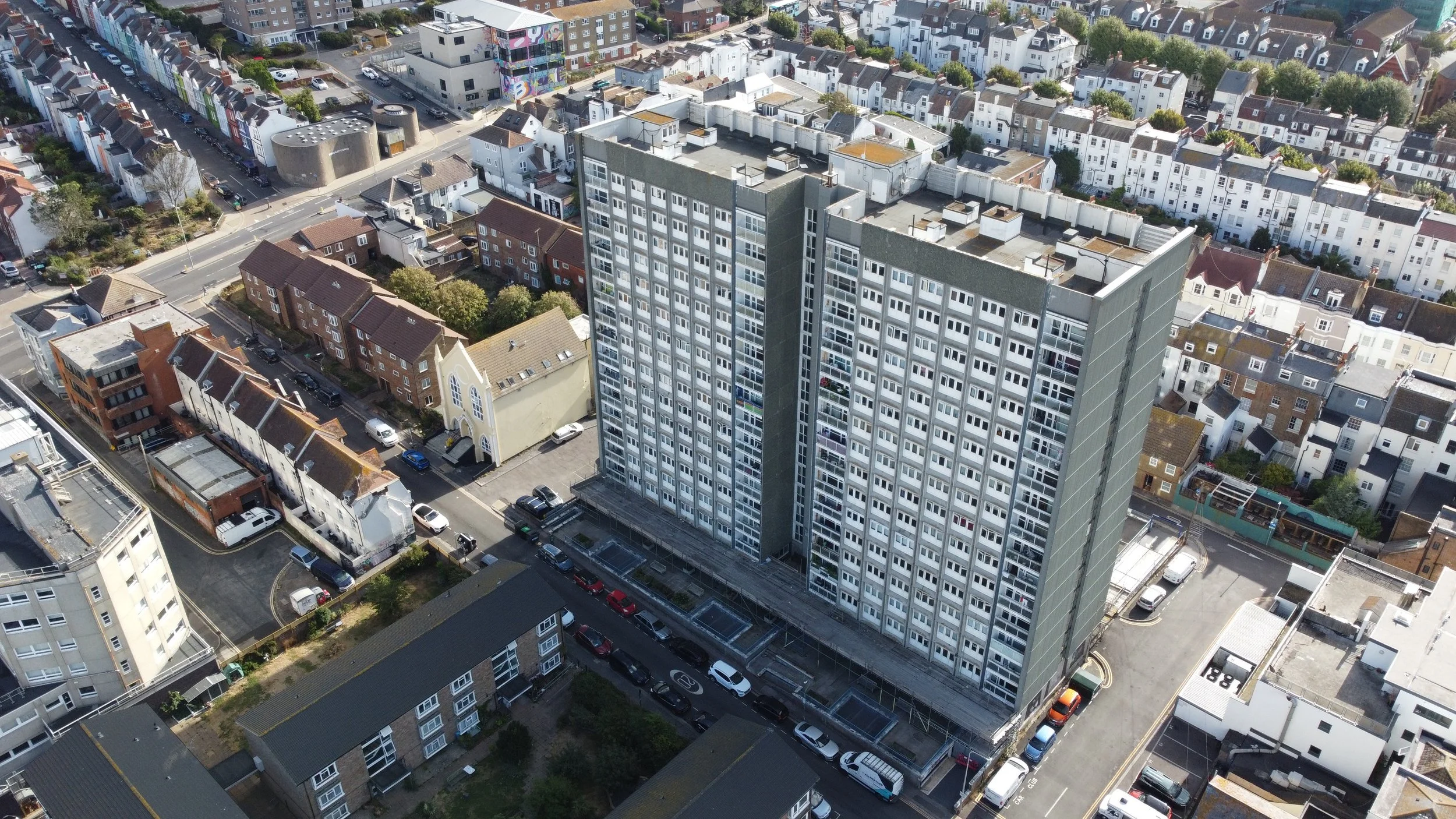 Aerial view of a tower block with scaffolding in a Brighton street