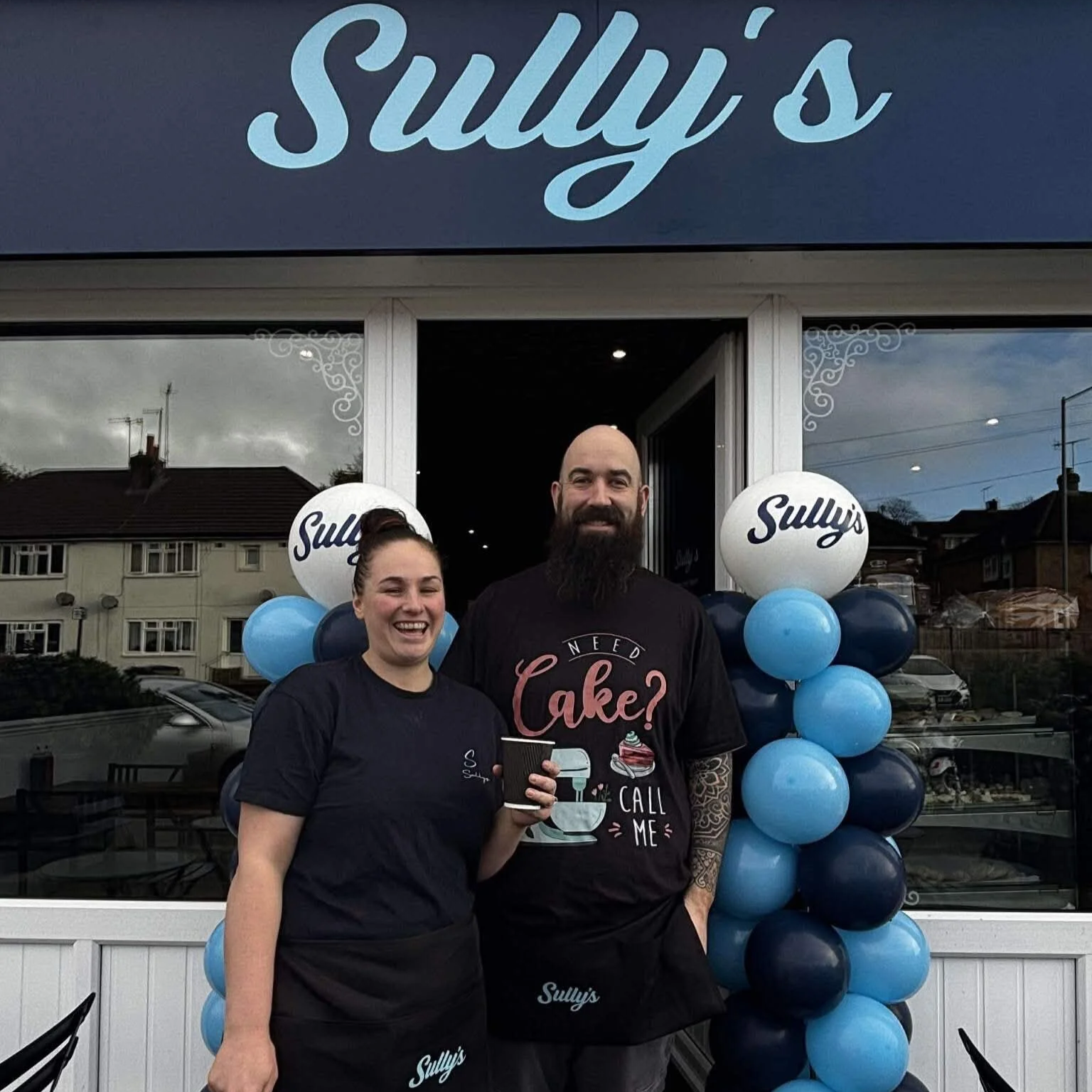 Graham and Ami, owners of Sully's coffee shop, smiling outside the cafe at 88 Valley Road Mile Oak Portslade