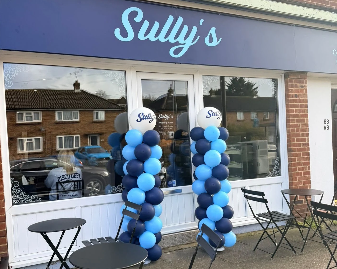 Sully's coffee shop front on Valley Road Mile Oak Portslade decorated with blue balloon columns and outdoor tables