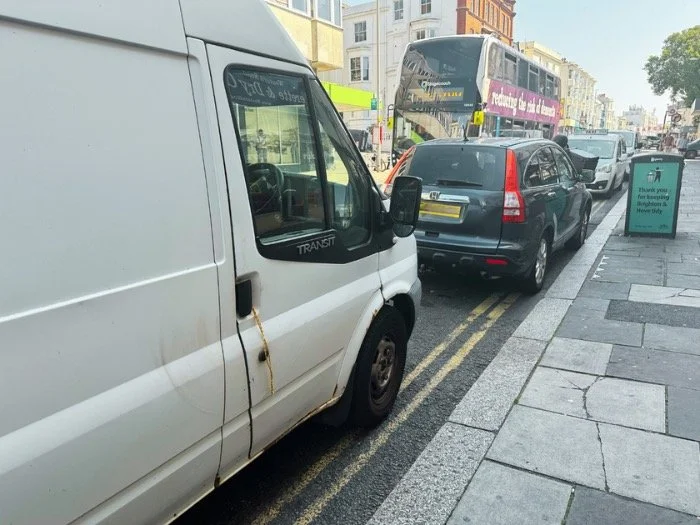 Vehicles queued on the double yellow lines on Western Road, Brighton, with a bus behind